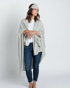 Woman shown wearing Light Gray Travel Set blanket and eye mask