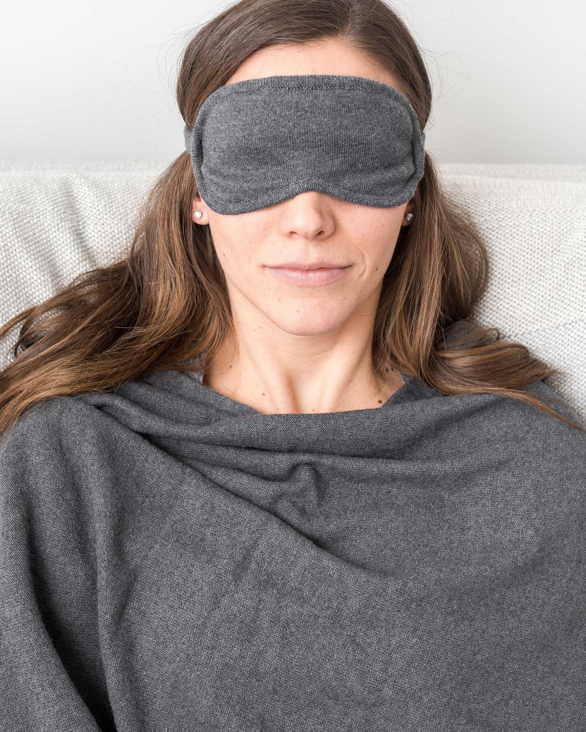 Woman shown wearing Dark Gray Travel Set blanket and eye mask