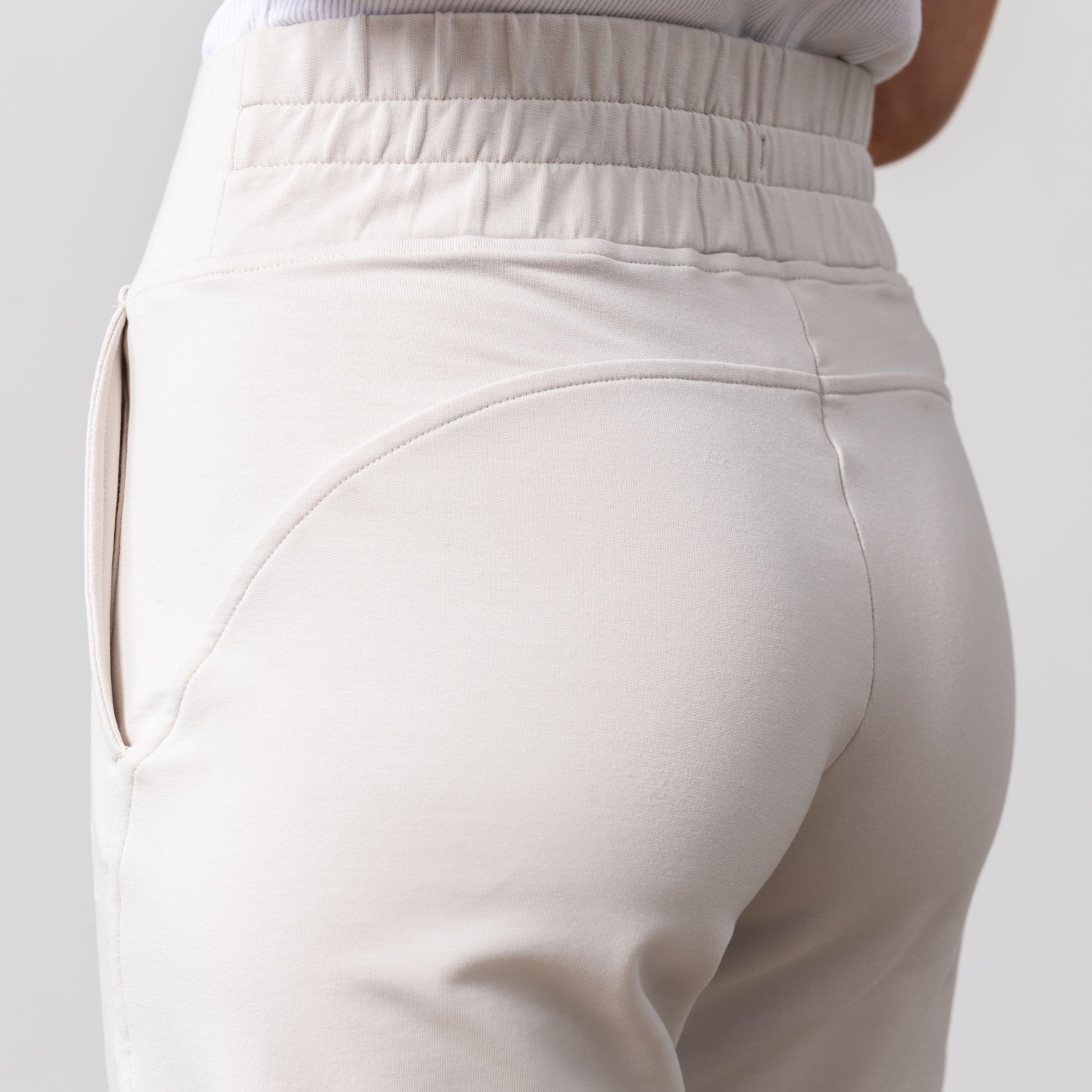 Woman shown wearing light beige pants
