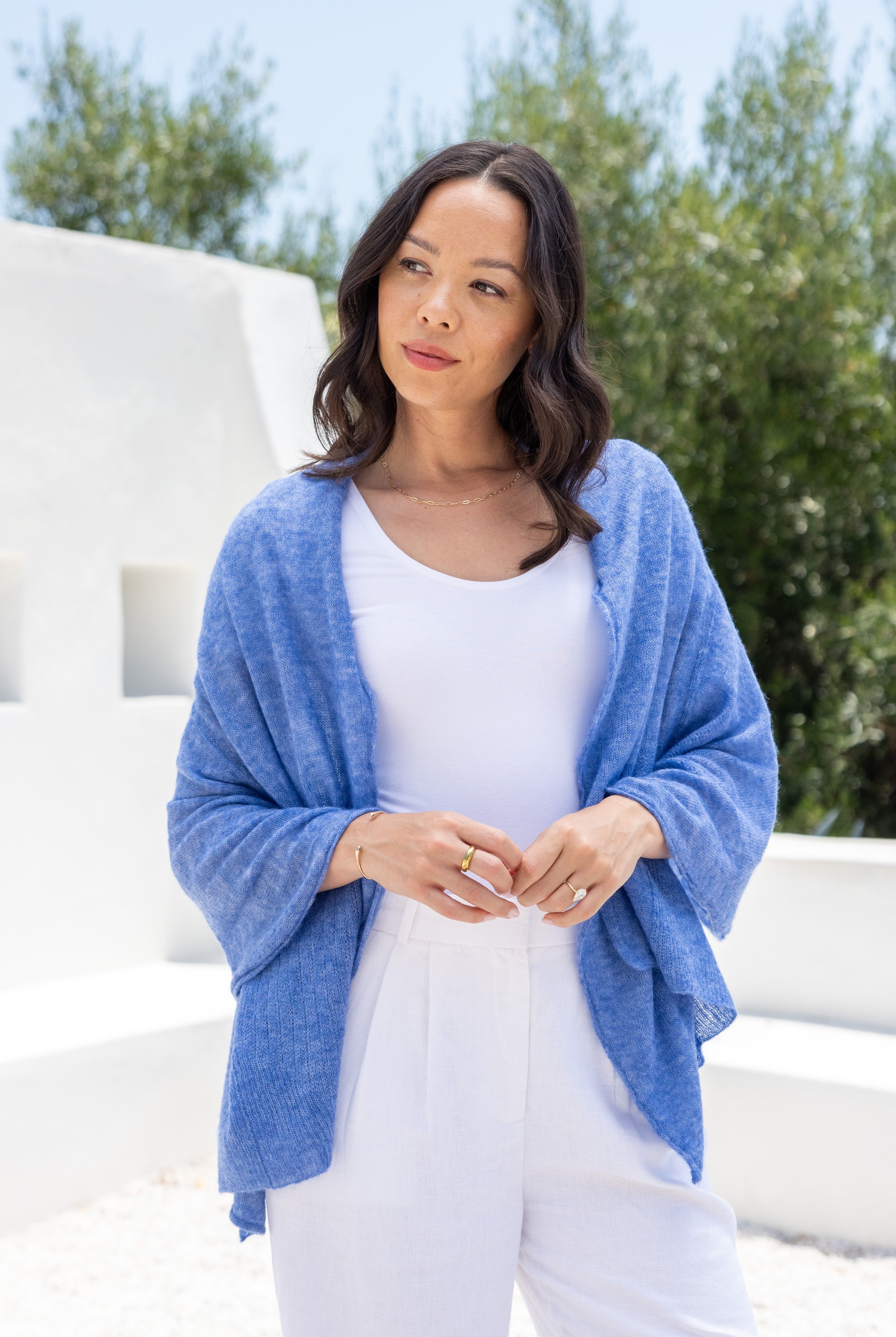 Woman shown wearing a blue scarf draped over her shoulders