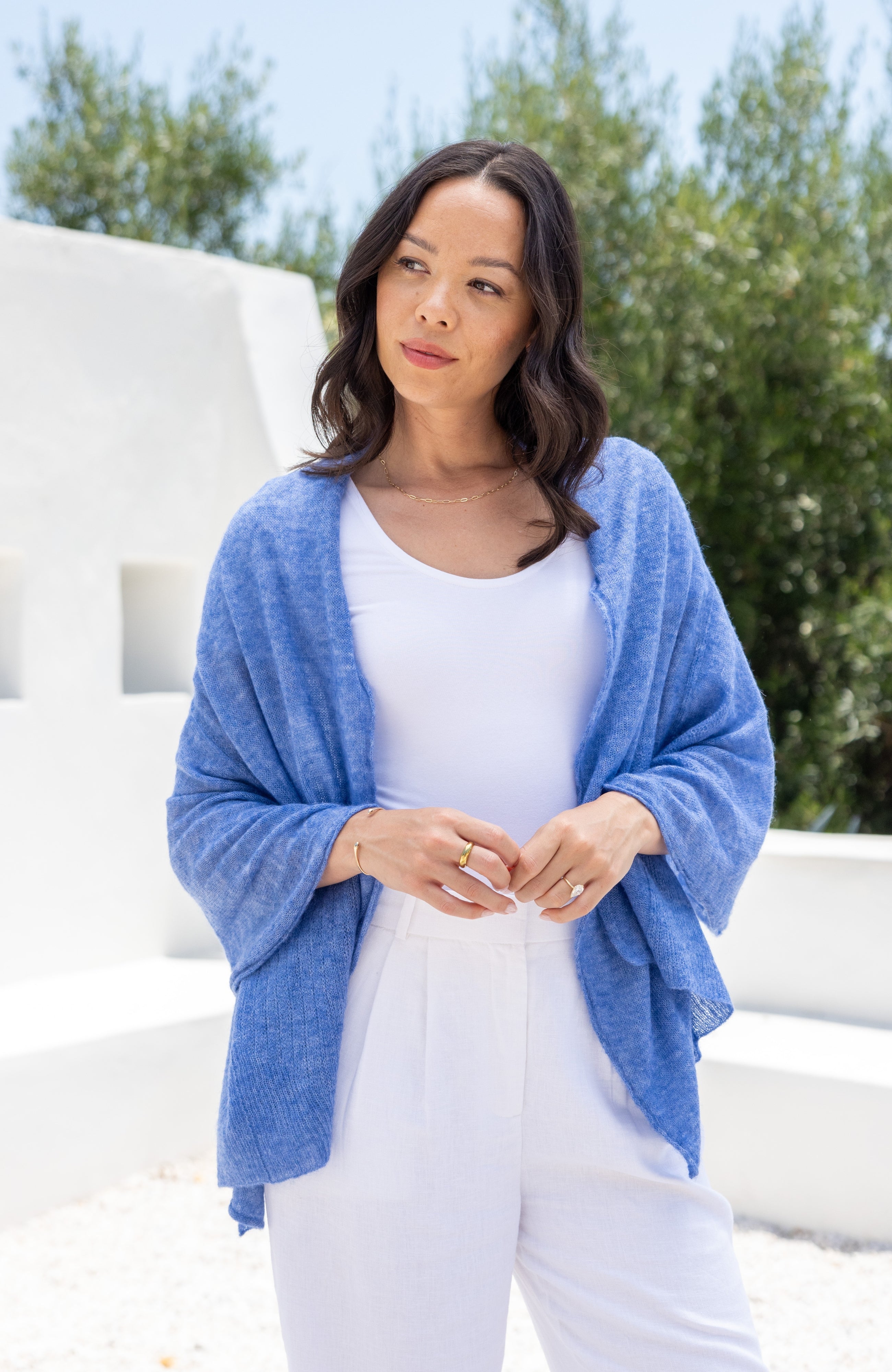 Woman shown wearing a blue scarf draped over her shoulders