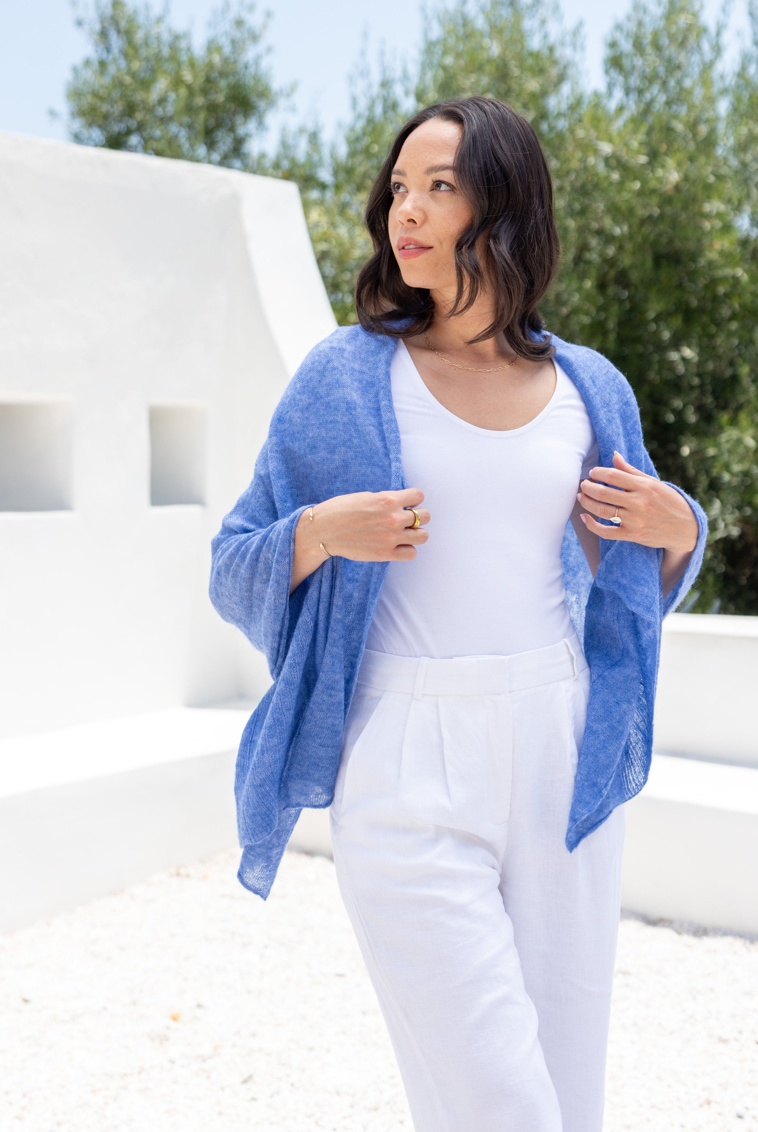 Woman shown wearing a blue scarf draped over her shoulders