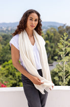 Woman shown wearing an Ivory scarf draped around her neck