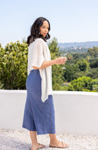 Woman shown wearing an Ivory scarf draped over her shoulders holding a glass of wine