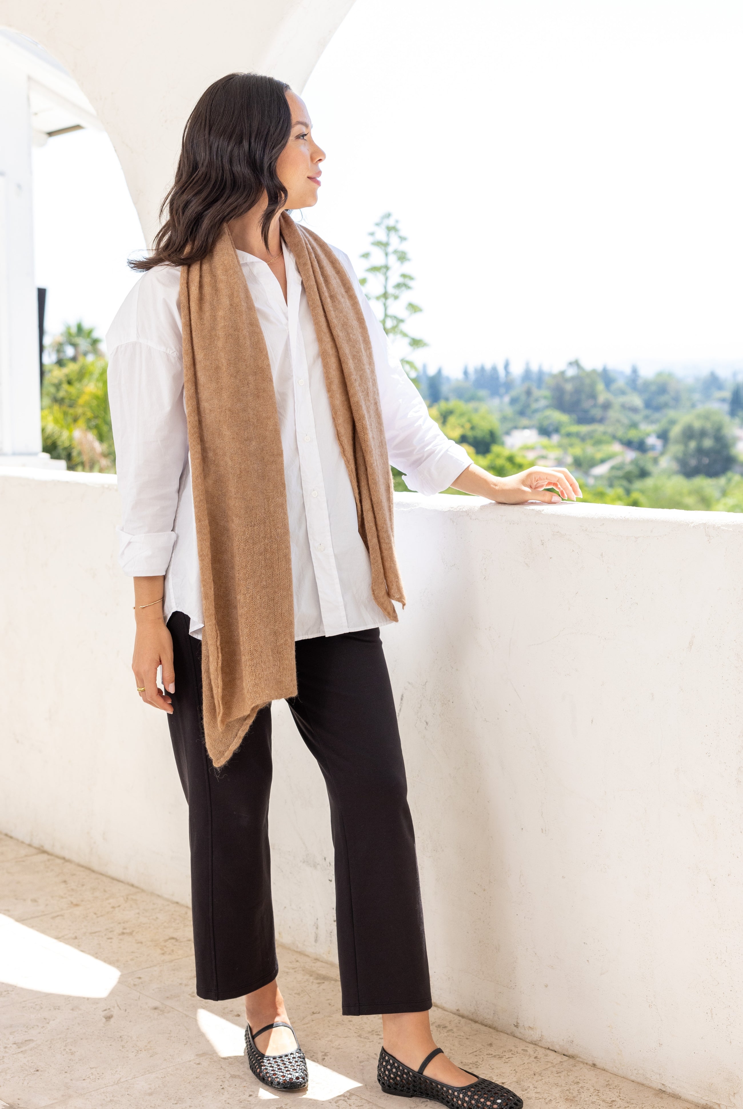 Woman shown wearing a beige scarf draped around her neck