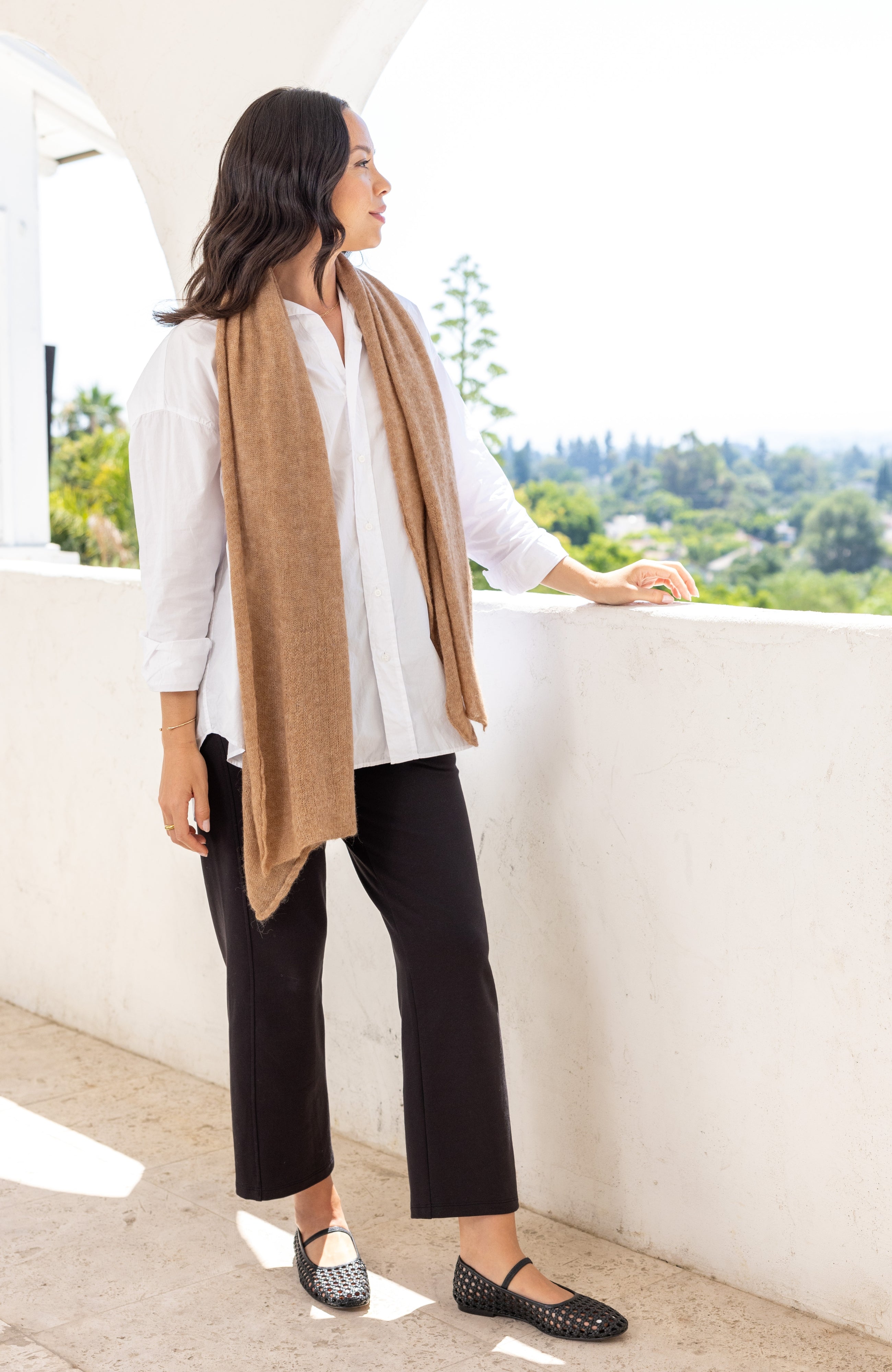 Woman shown wearing a beige scarf draped around her neck