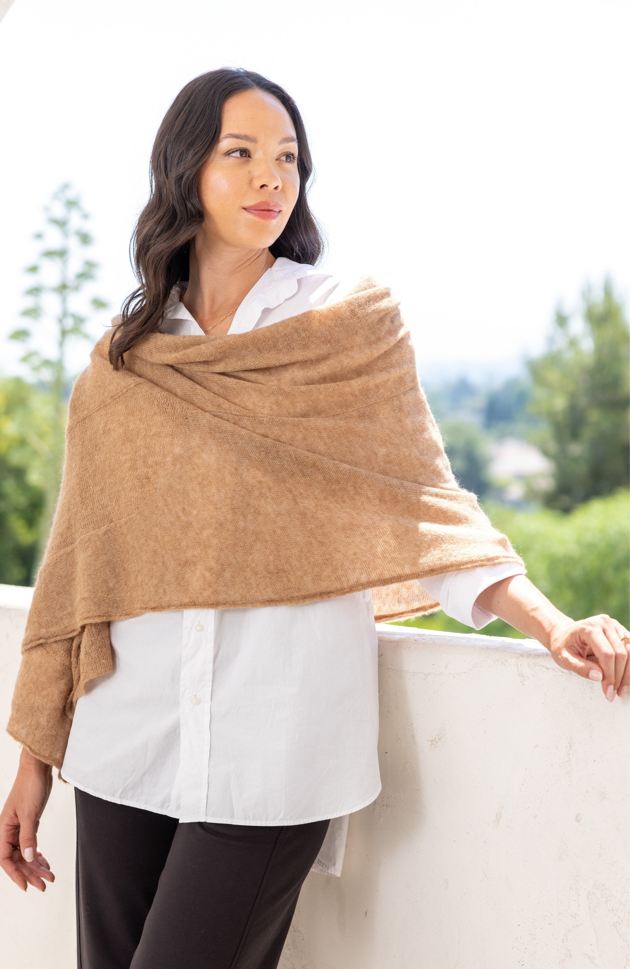 Woman shown wearing a beige scarf draped over her shoulders