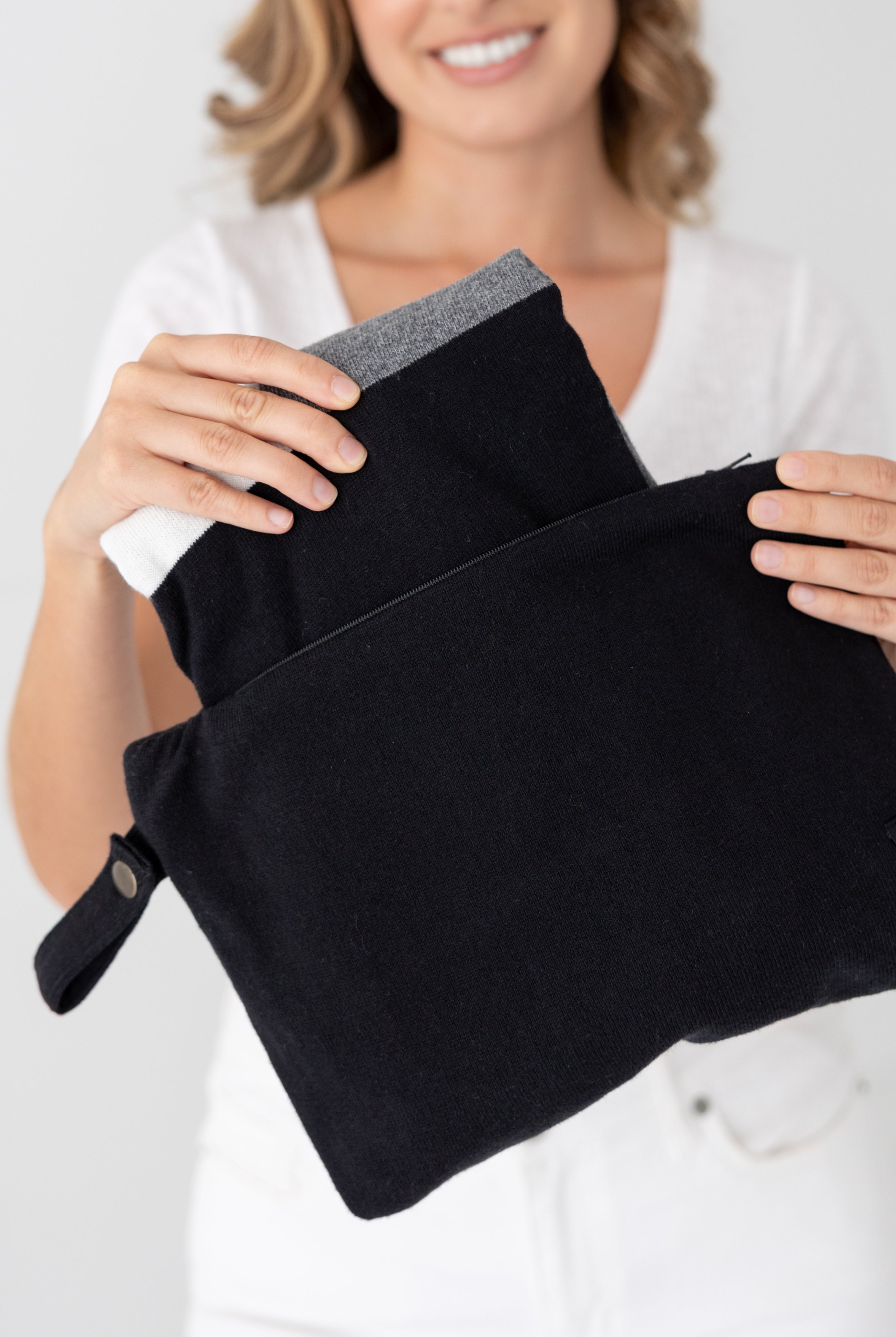 Woman shown pulling scarf out of the black carry pouch
