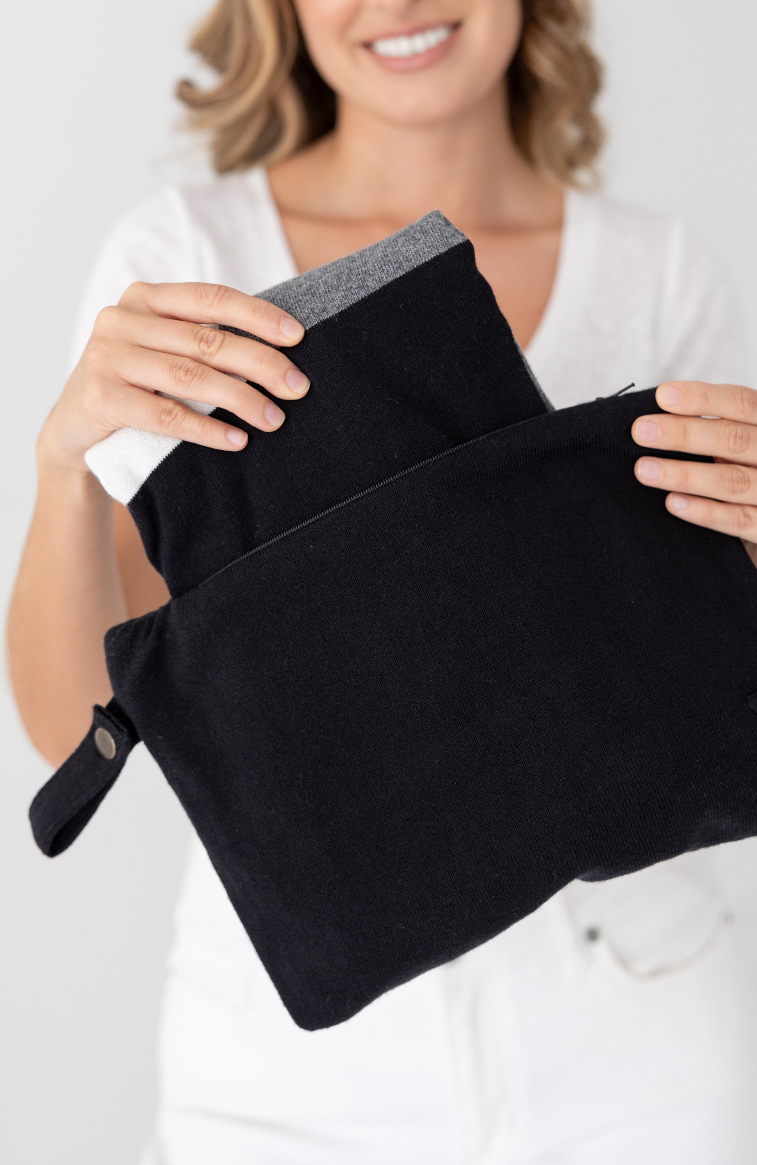 Woman shown pulling scarf out of the black carry pouch