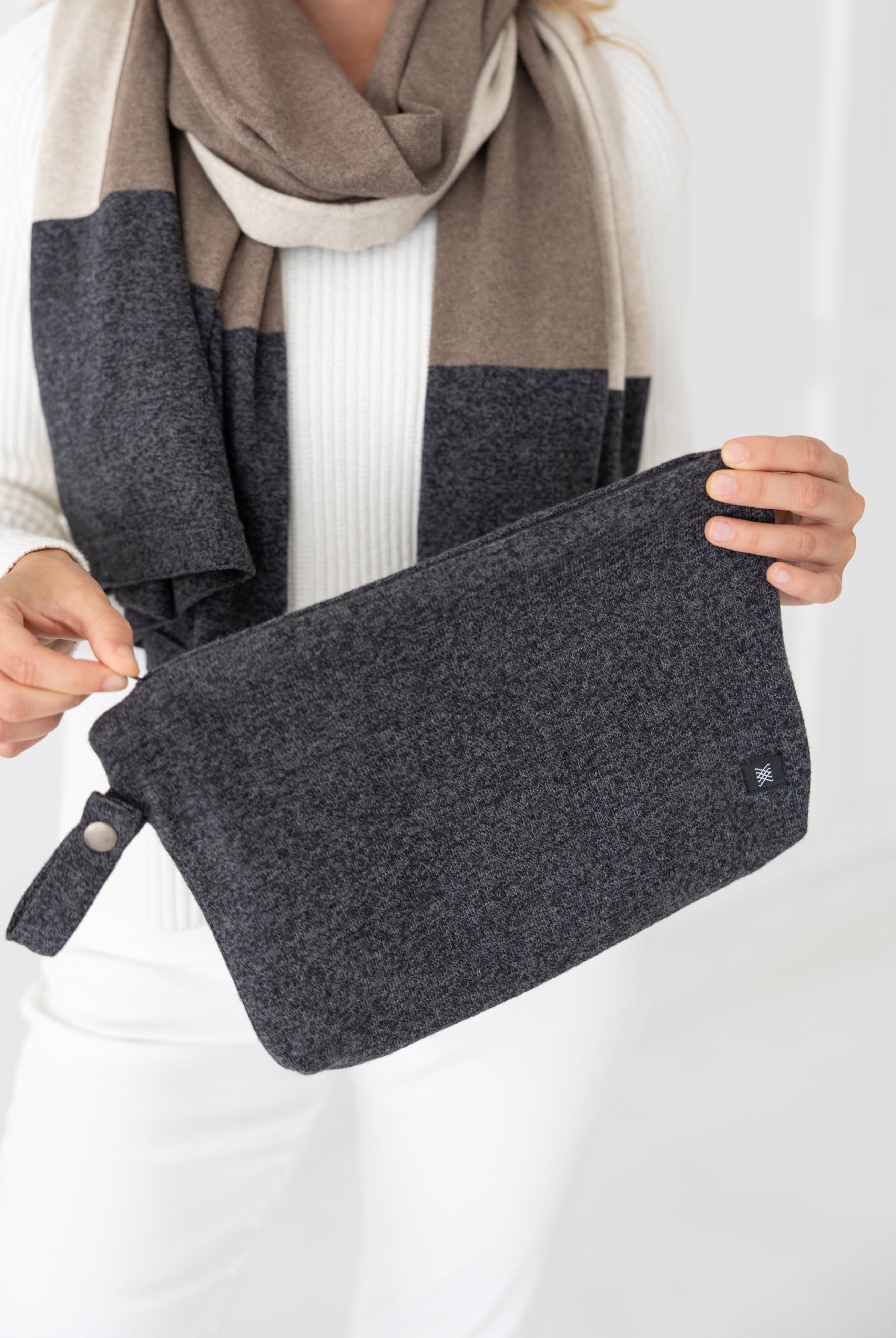 woman shown holding gray carry pouch