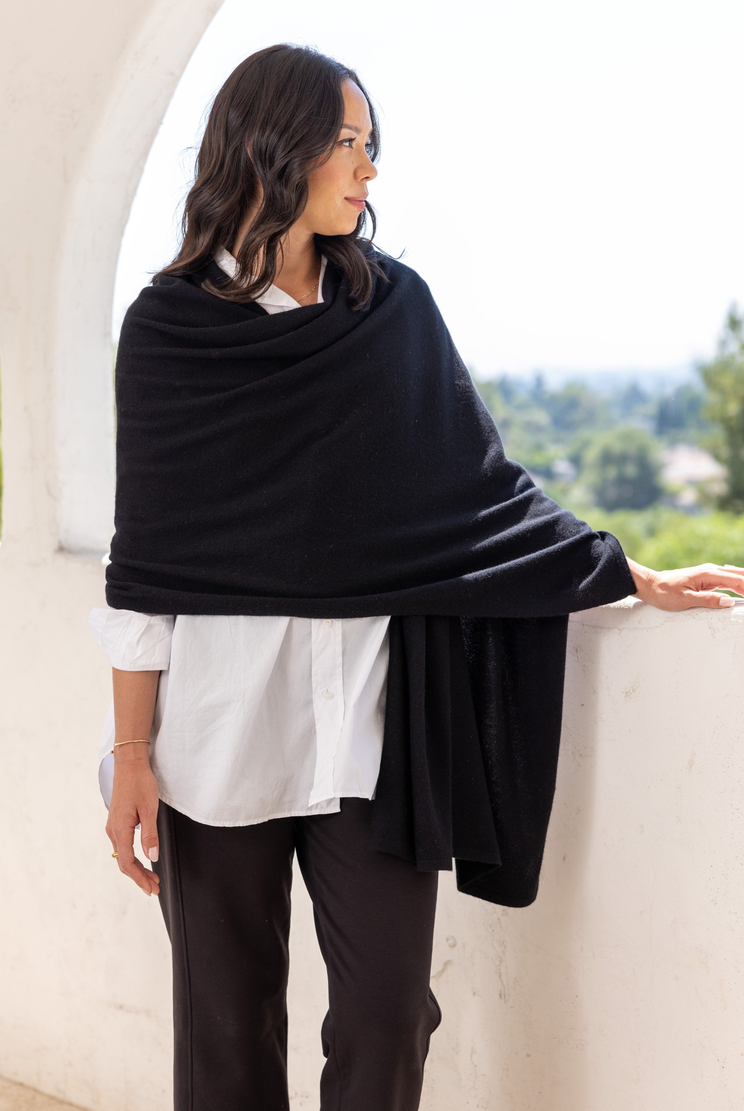 Woman shown wearing a black scarf draped around her shoulders