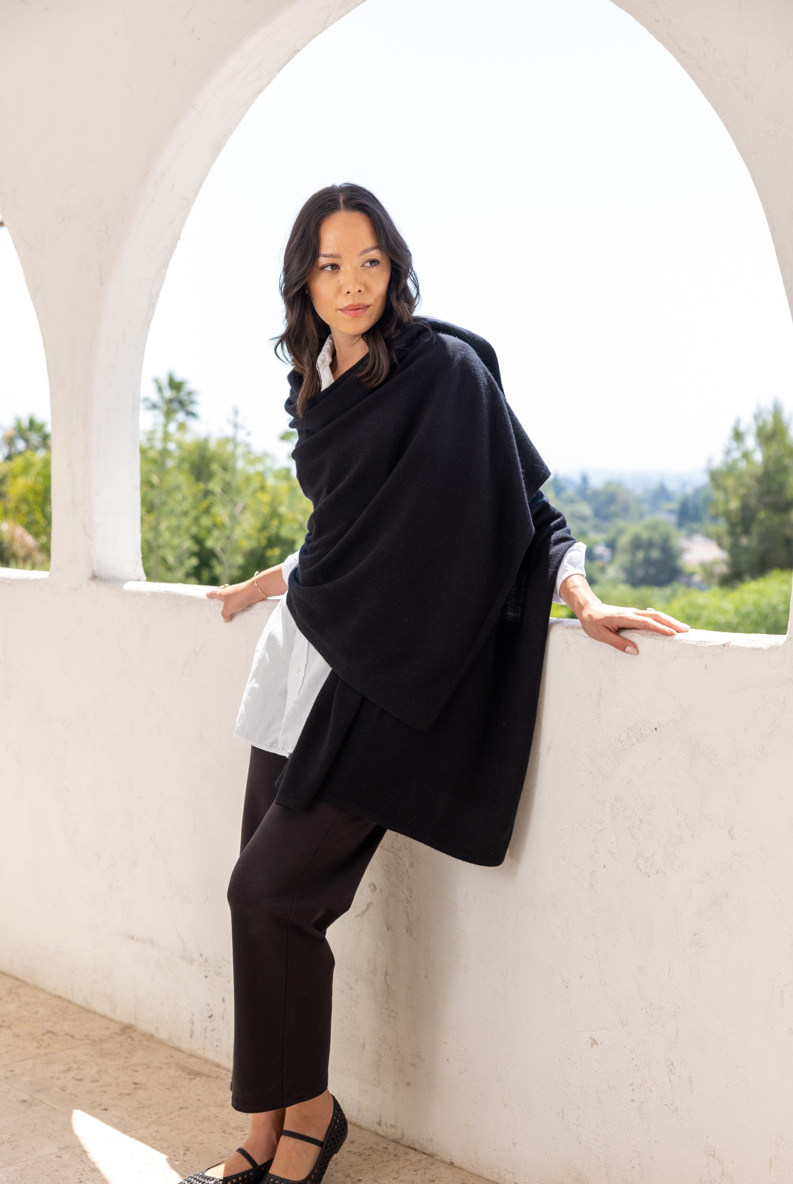 Woman shown wearing a black scarf draped around her shoulders