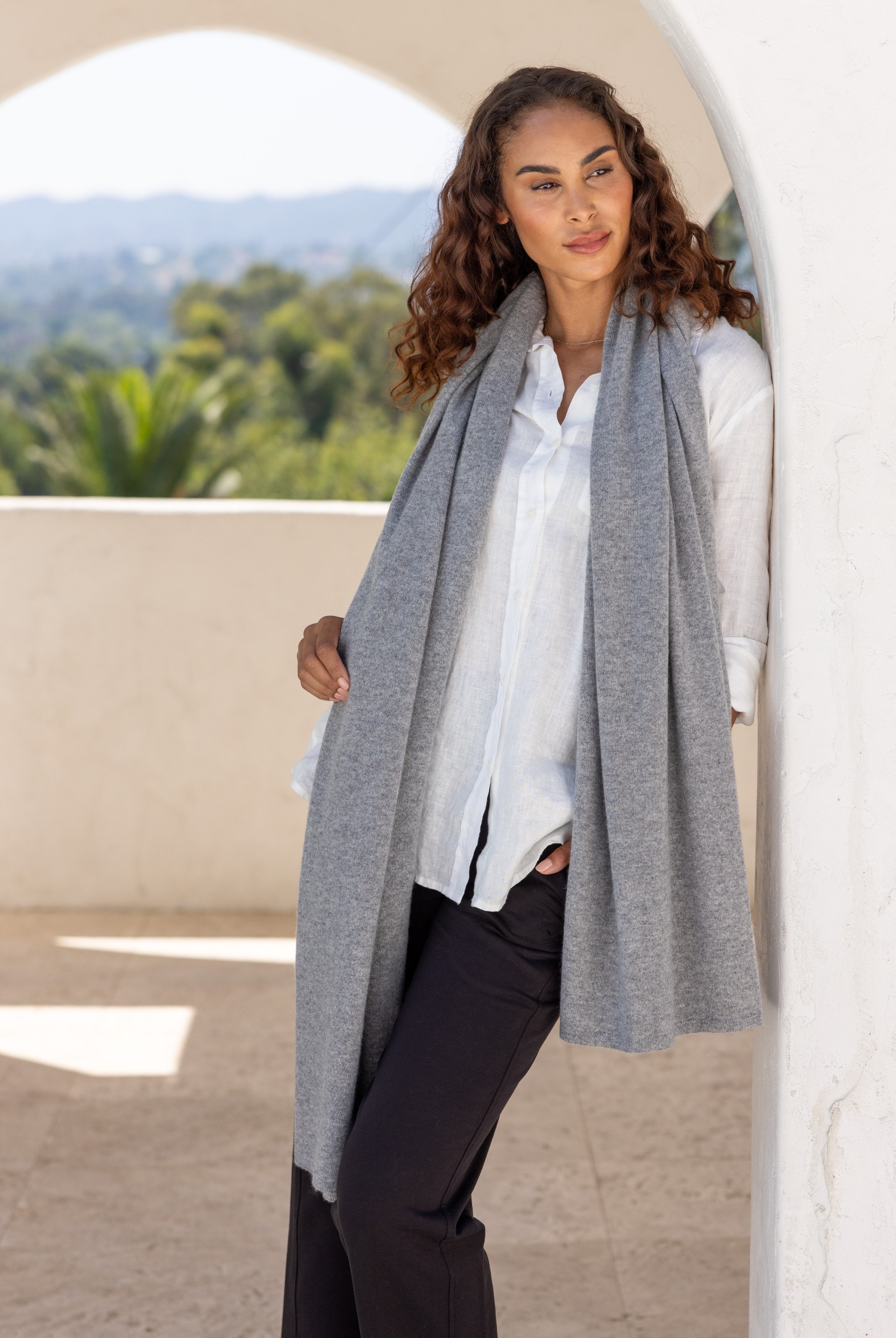 Woman shown wearing a gray scarf draped around her neck