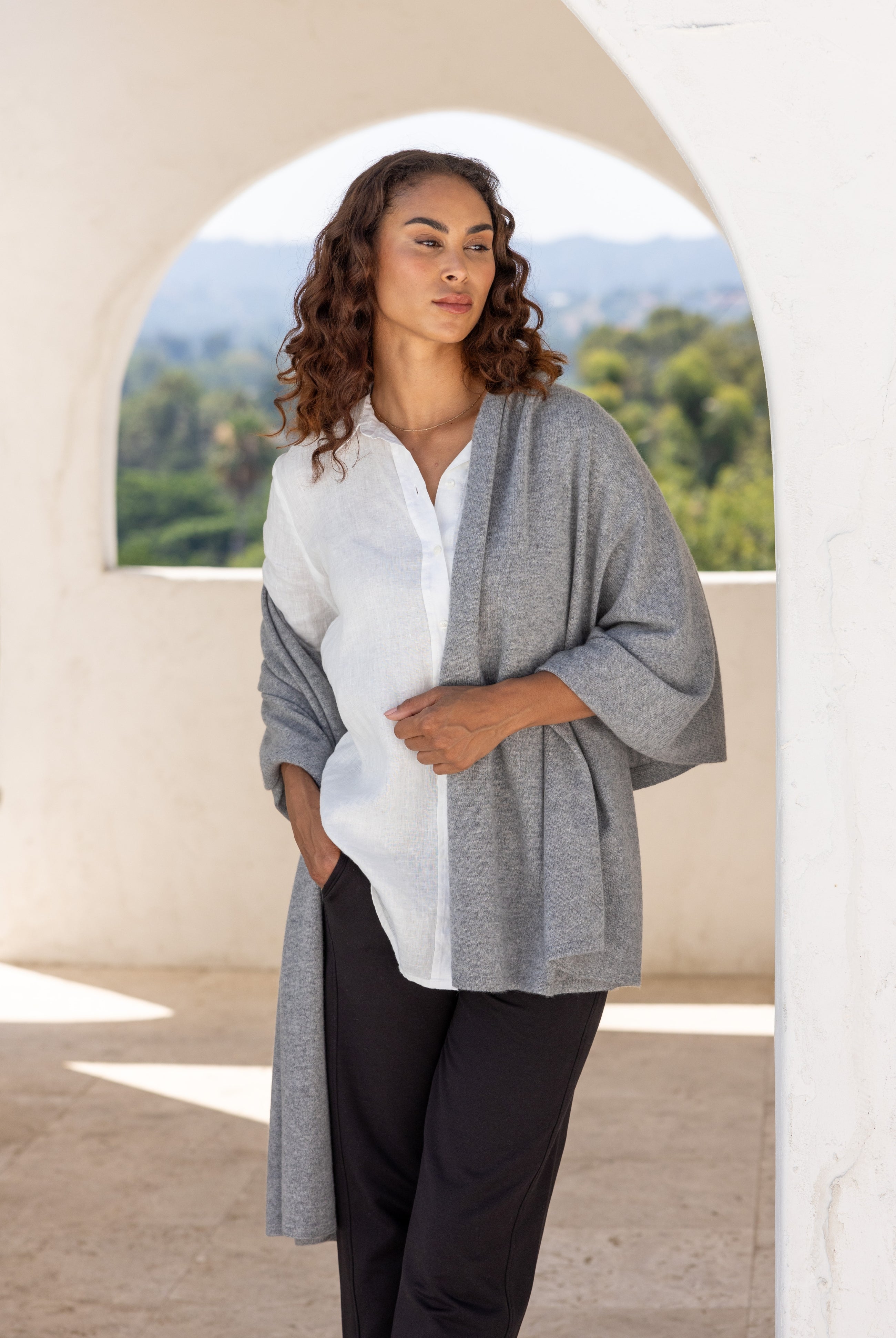 Woman shown wearing a gray scarf draped over her shoulders