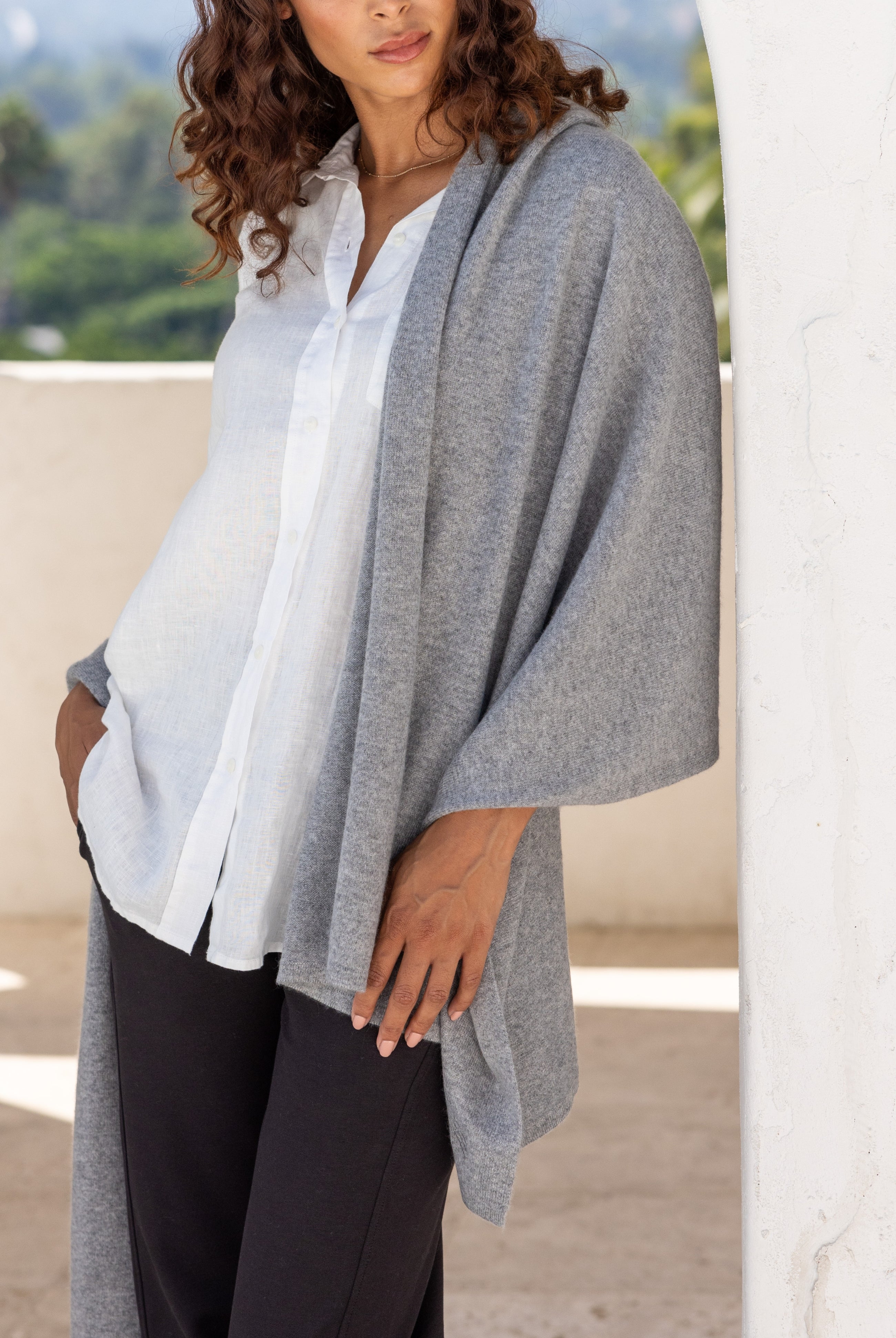Woman shown wearing a gray scarf draped over her shoulders