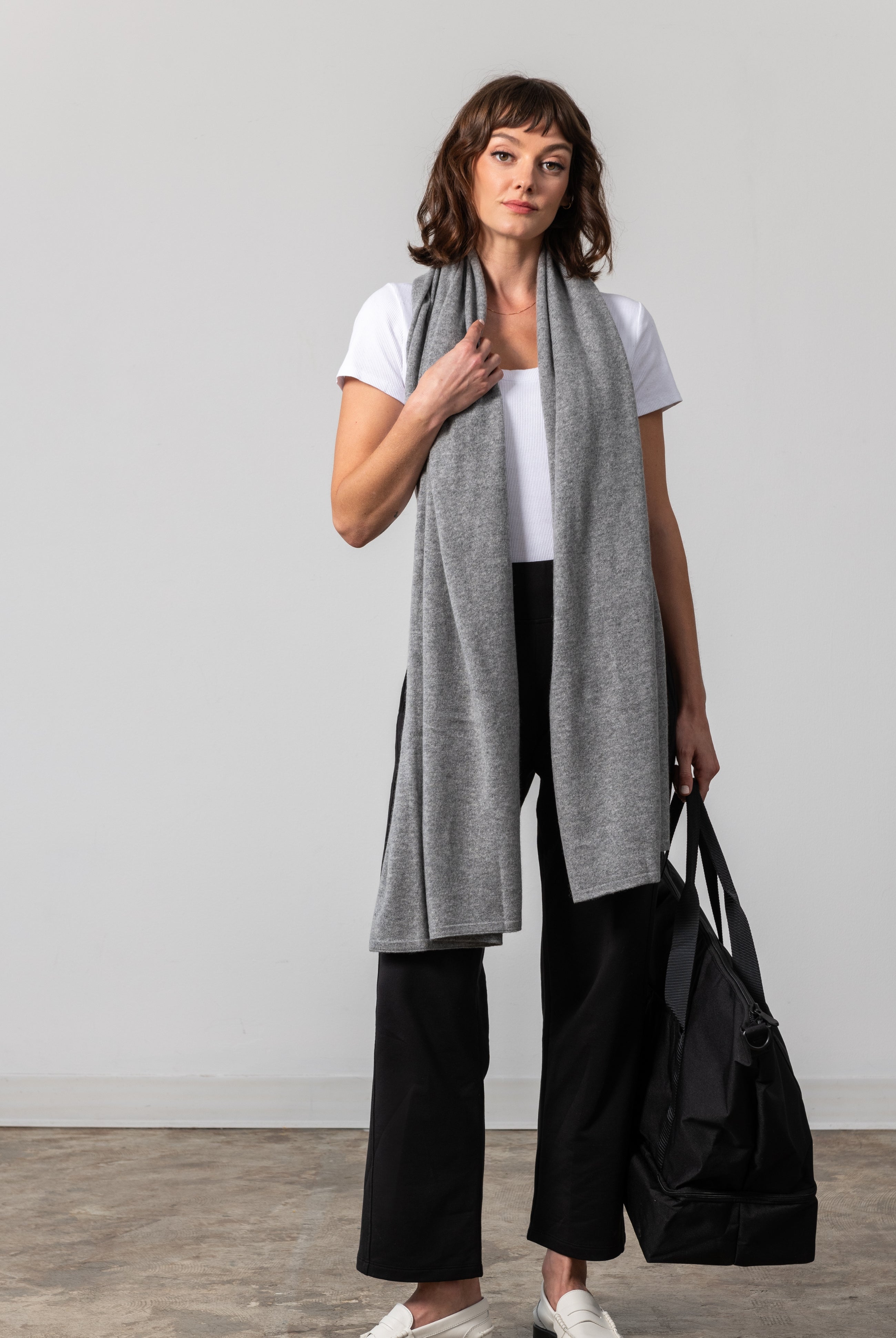 Woman shown wearing a gray scarf draped around her neck