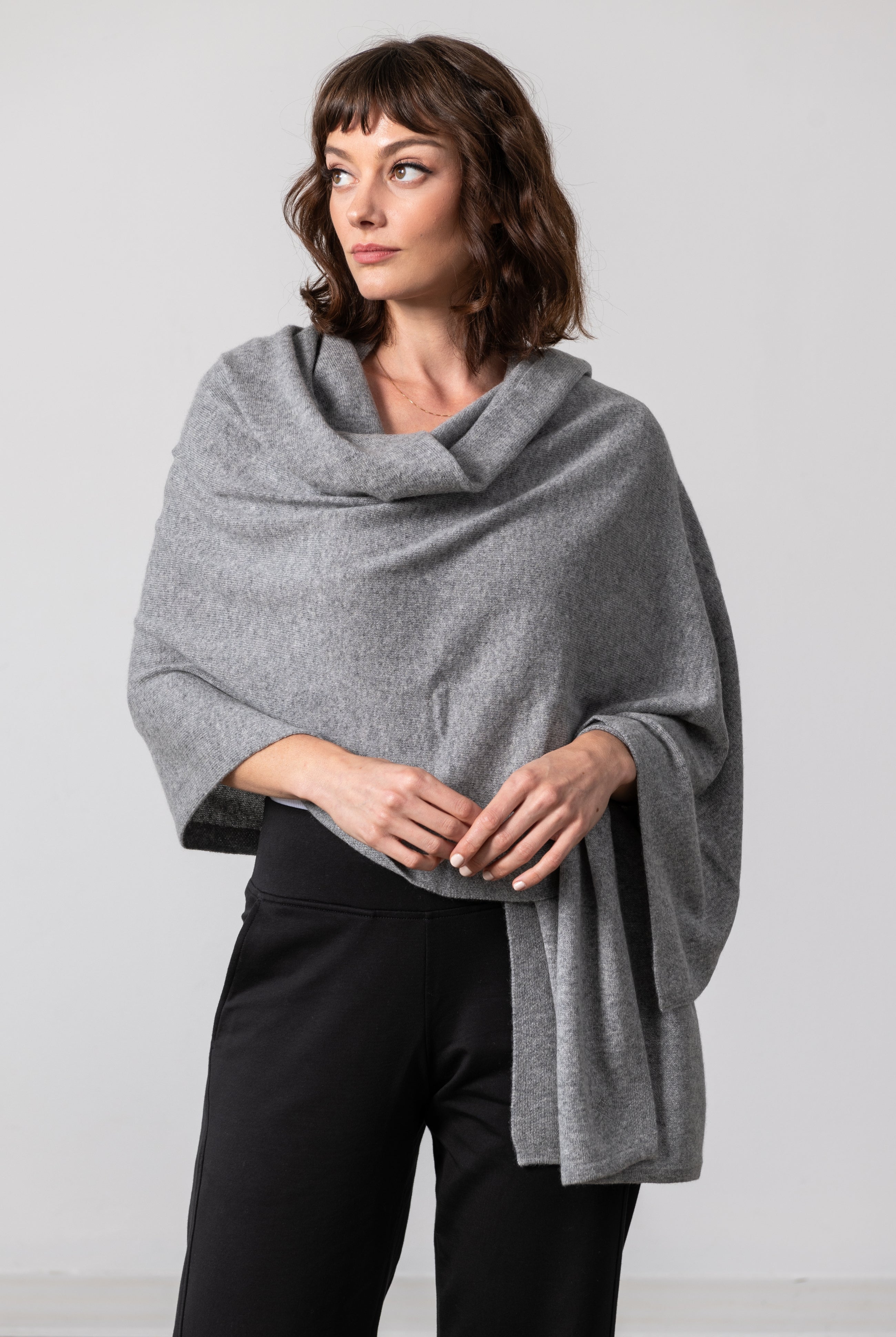 Woman shown wearing a gray scarf draped over her shoulders