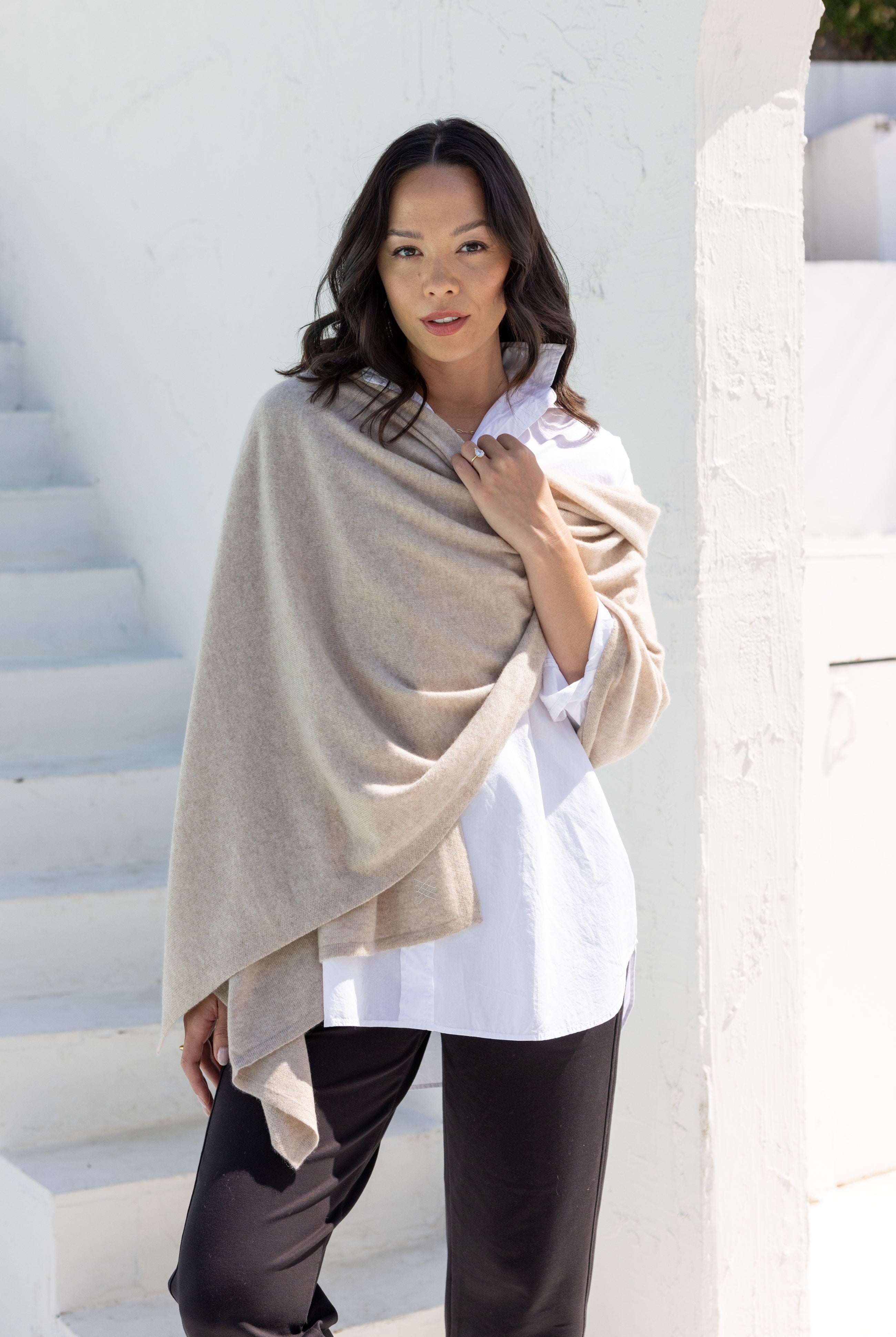 Woman shown wearing a beige scarf draped around her shoulders