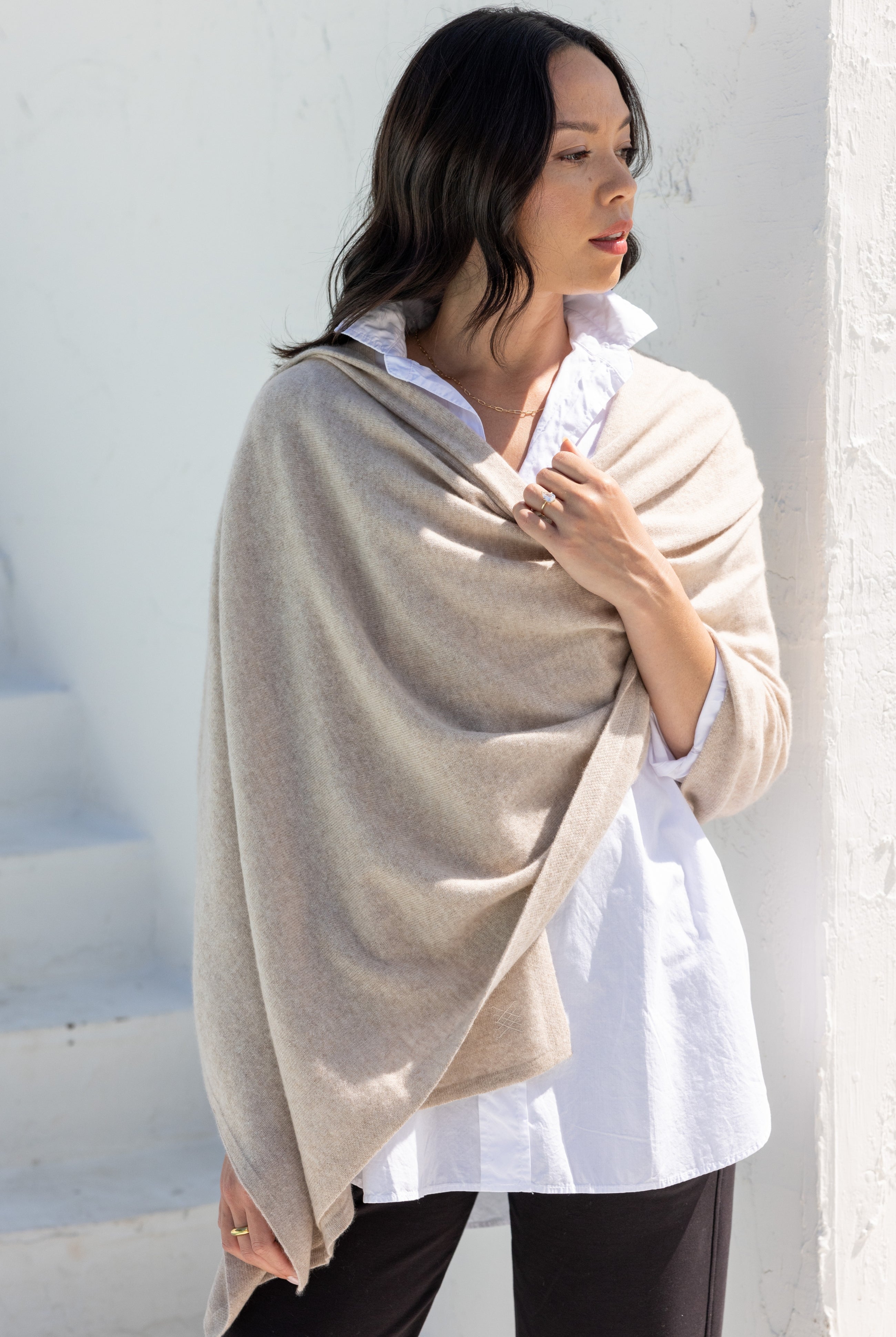 Woman shown wearing a beige scarf draped around her shoulders