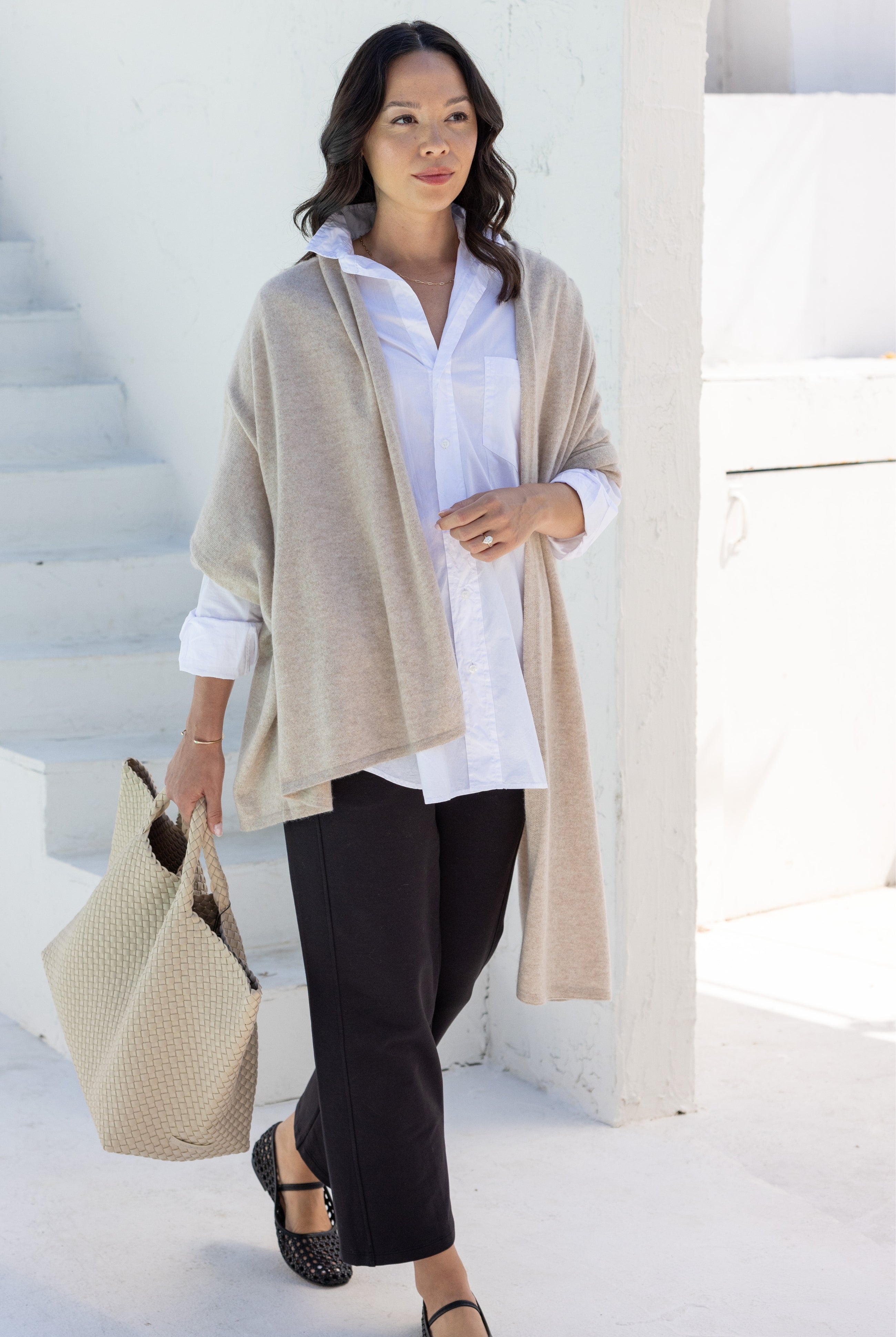 Woman shown wearing a beige scarf draped around her shoulders