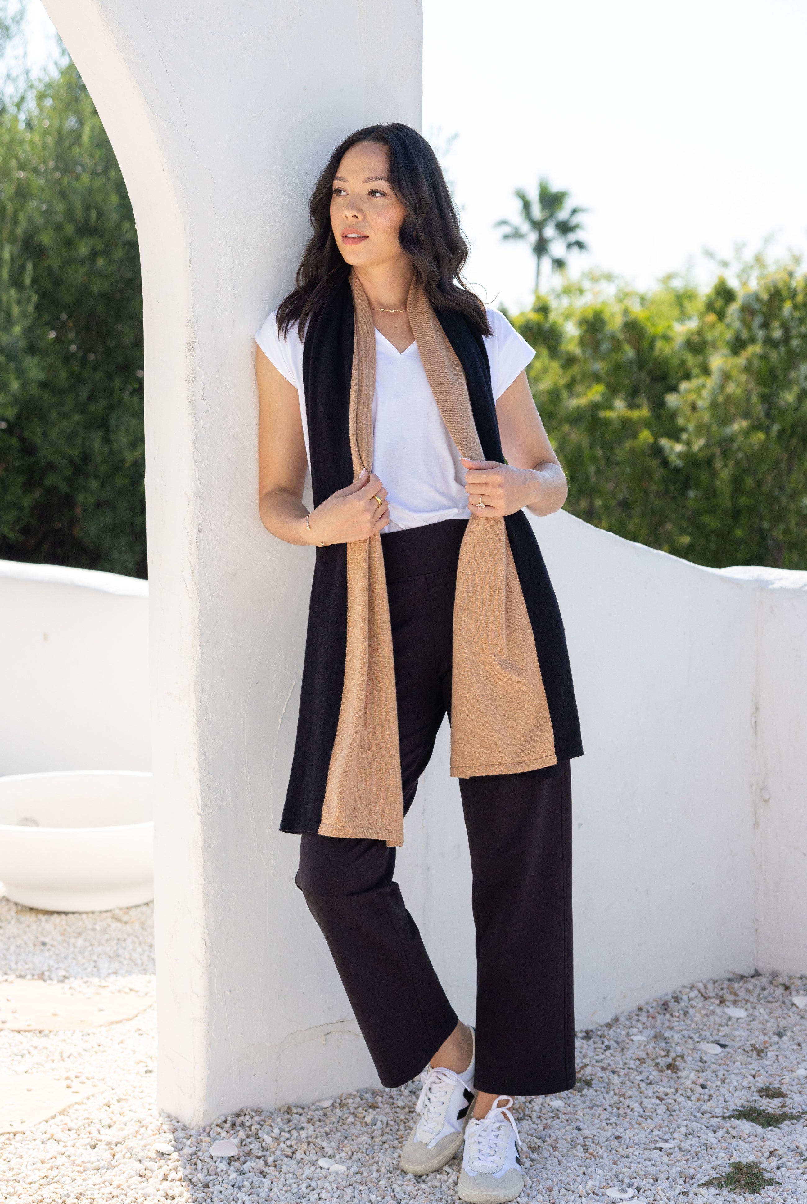 Woman shown wearing Black and Beige Scarf wrapped around her neck