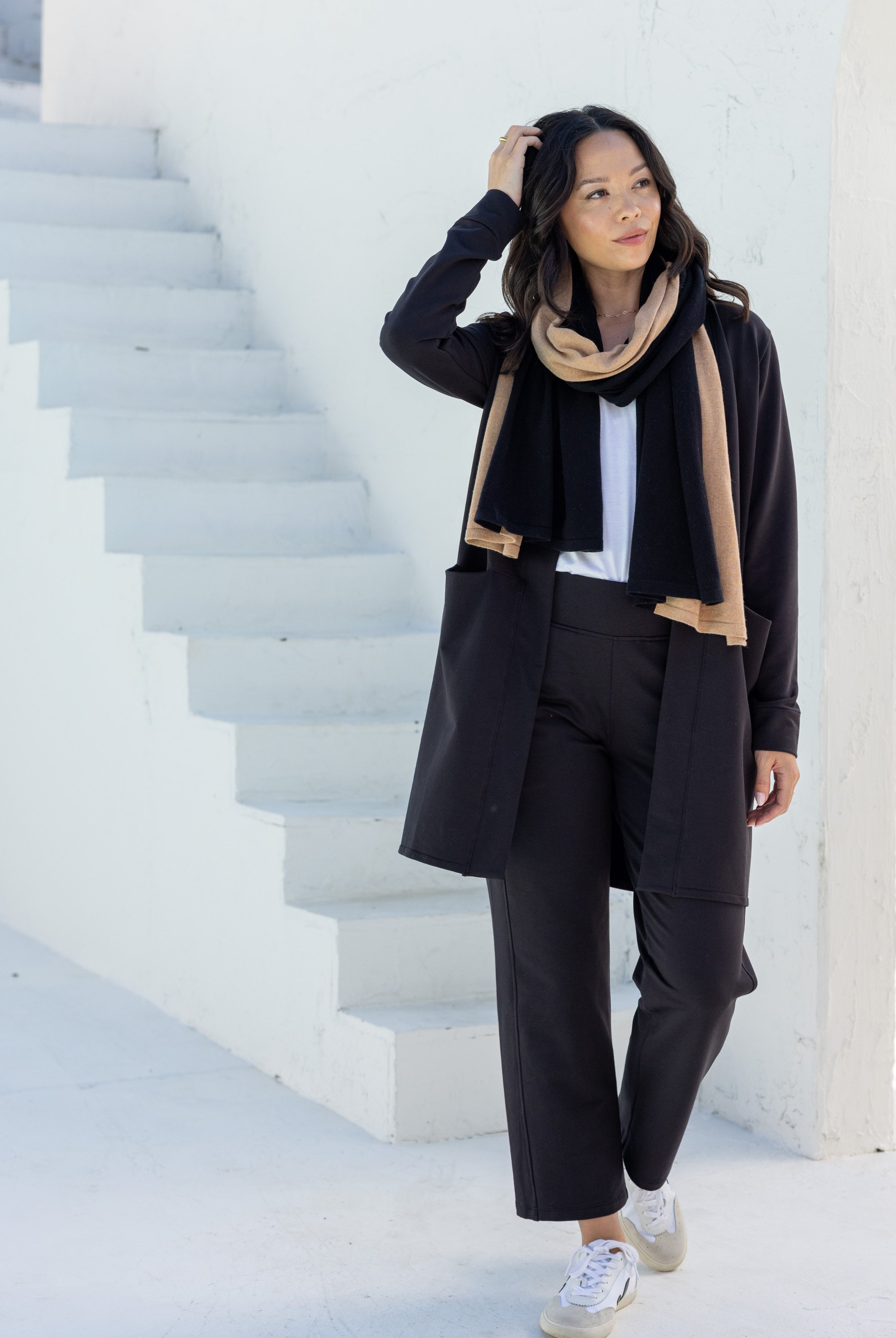 Woman shown wearing Black and Beige Scarf wrapped around her neck