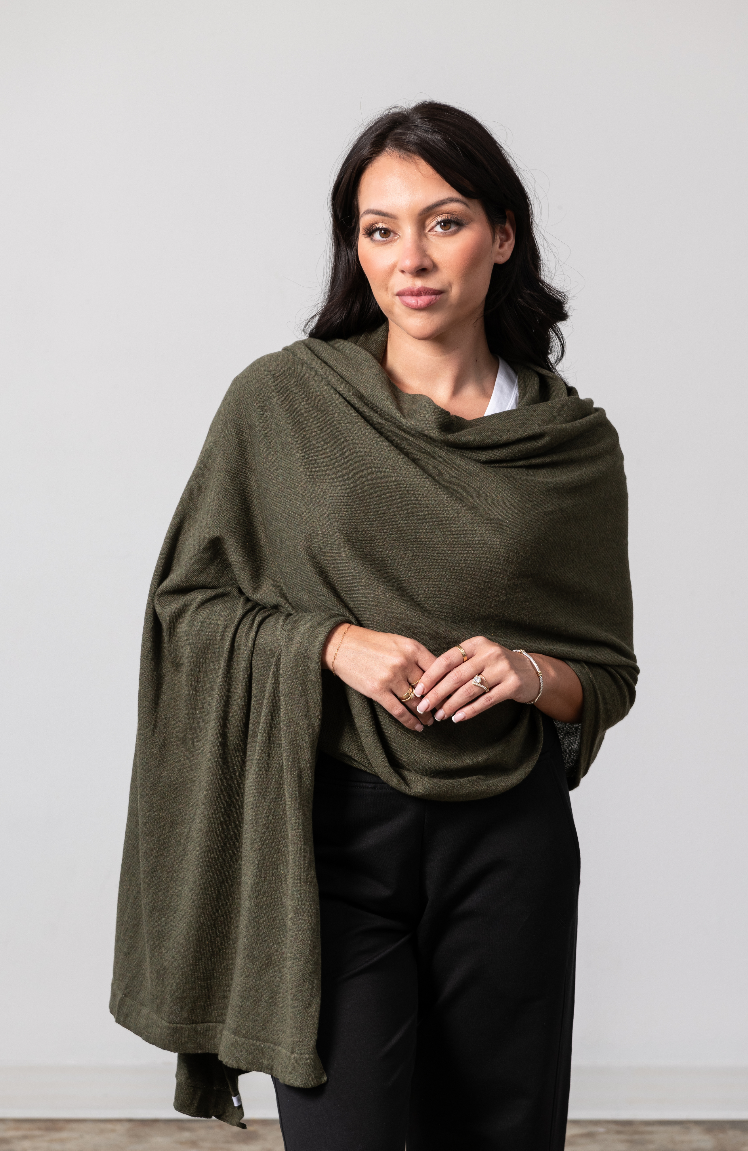 Women shown wearing a dark green scarf draped over her shoulders