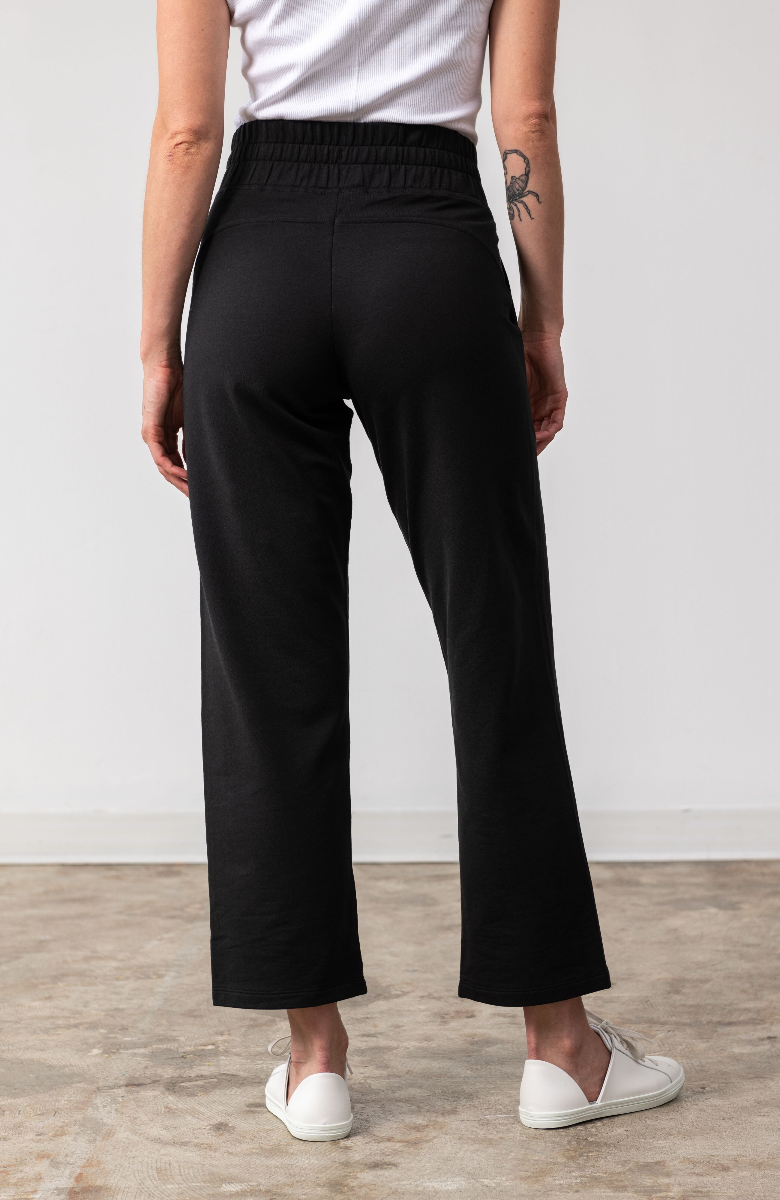 Woman shown wearing black pants