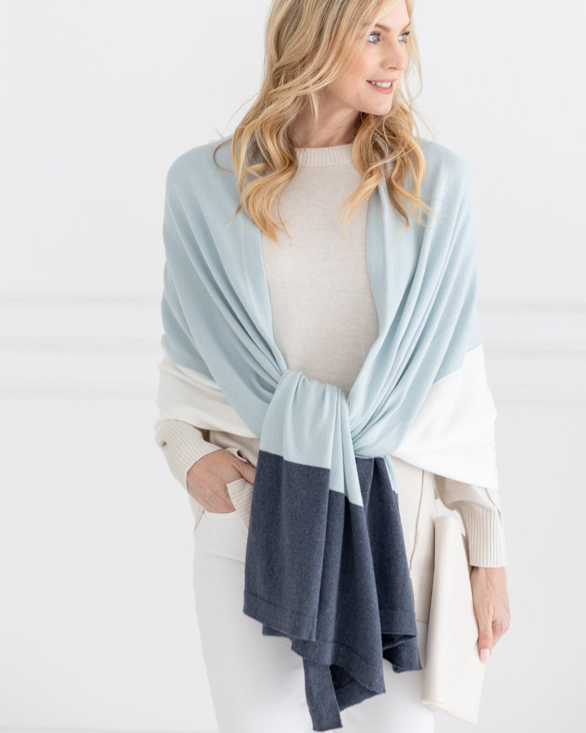 Woman  wearing the Dreamsoft Travel Scarf in Sky Blue Colorblock which is a light blue, gray and cream scarf, worn as a wedding knot style