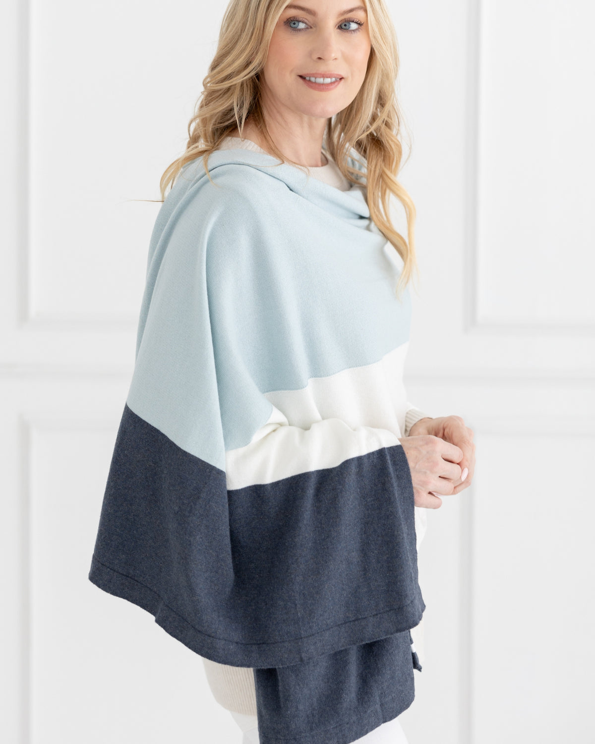 Woman wearing the Dreamsoft Travel Scarf in Sky Blue Colorblock which is a light blue, gray and cream scarf, worn as a wrap