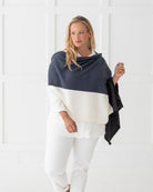 Woman wearing the Dreamsoft Travel Scarf in Denim Colorblock which is a dark blue, slate blue and cream scarf, as a wrap
