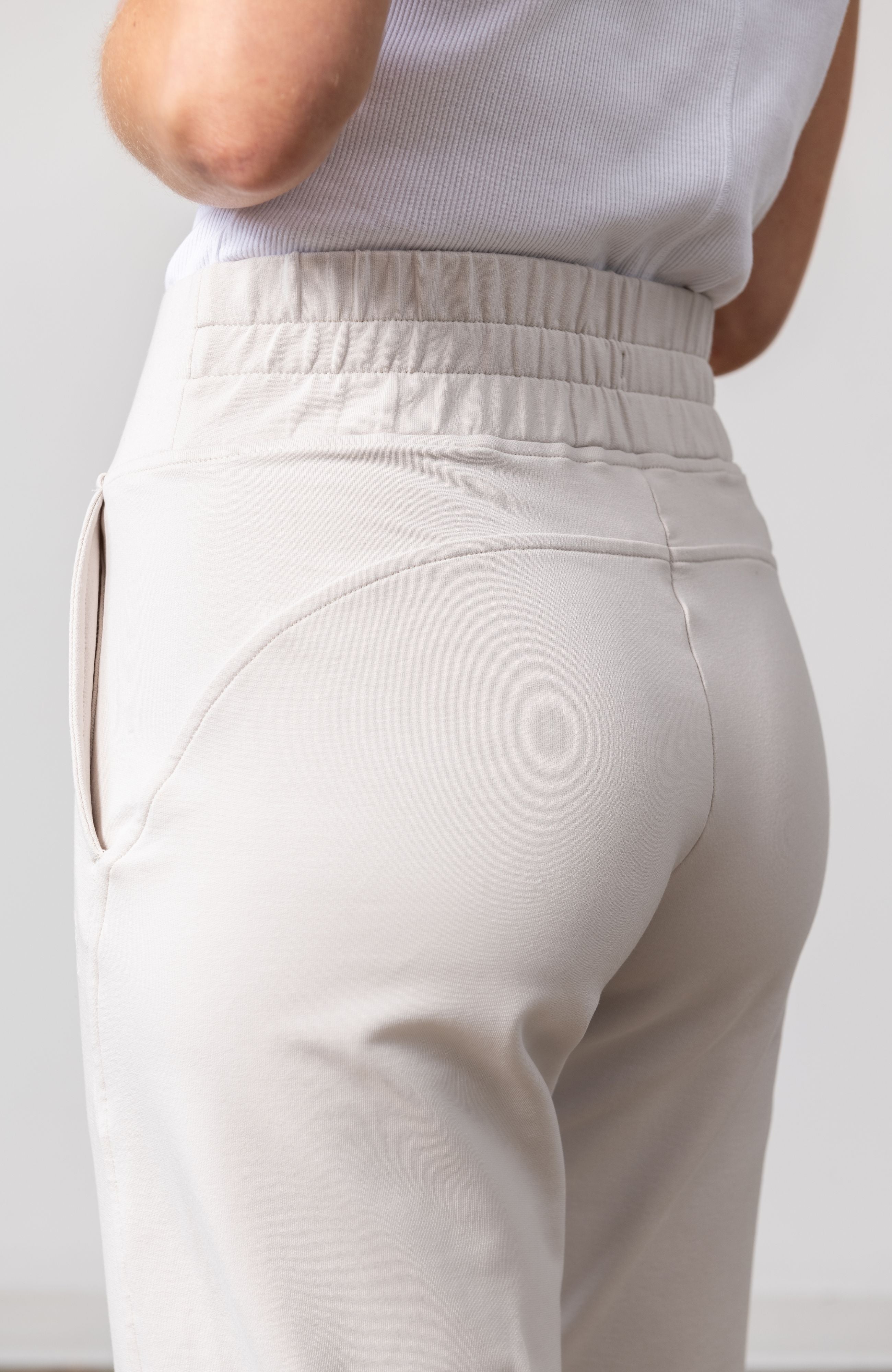 Woman shown wearing light beige pants