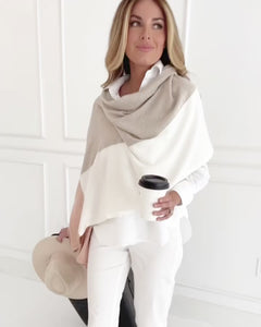Video of Woman wearing the Dreamsoft Travel Scarf in Blush Colorblock which is a pink, tan and cream scarf, pulling a suitcase while holding a cup of coffee