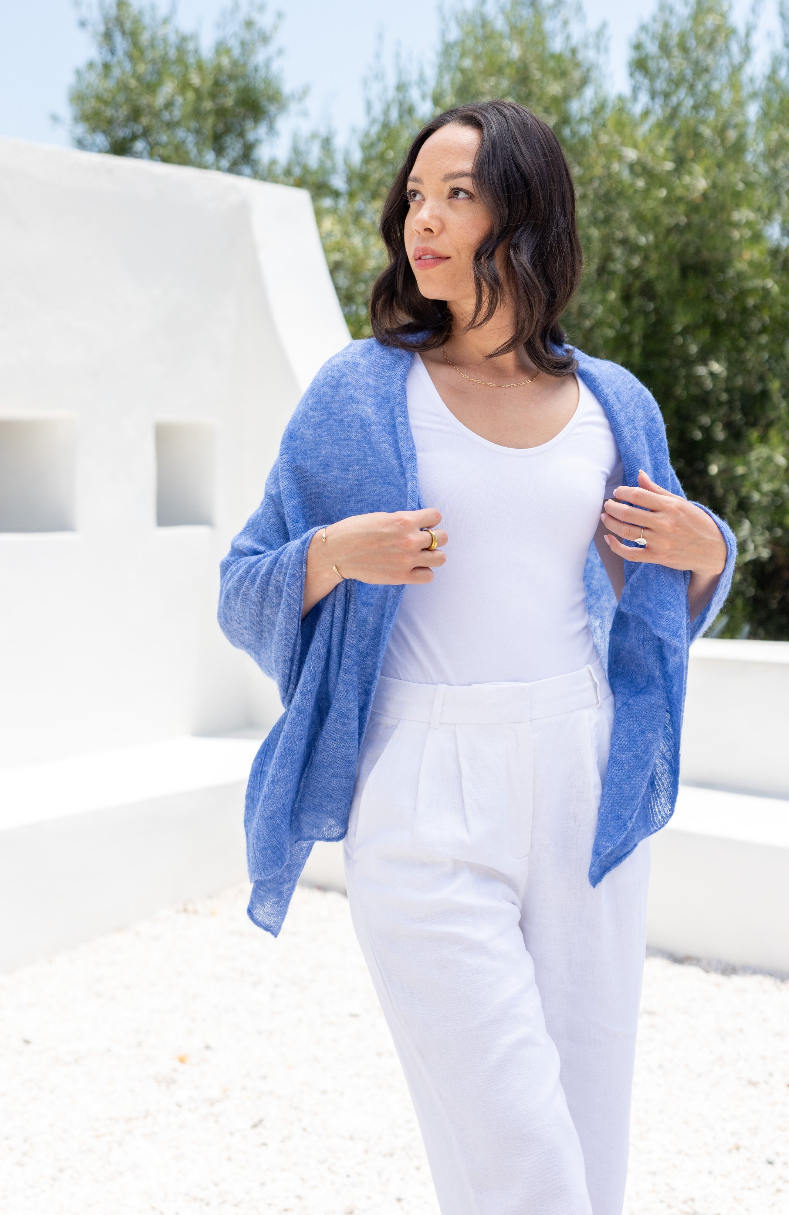 Woman shown wearing a blue scarf draped over her shoulders