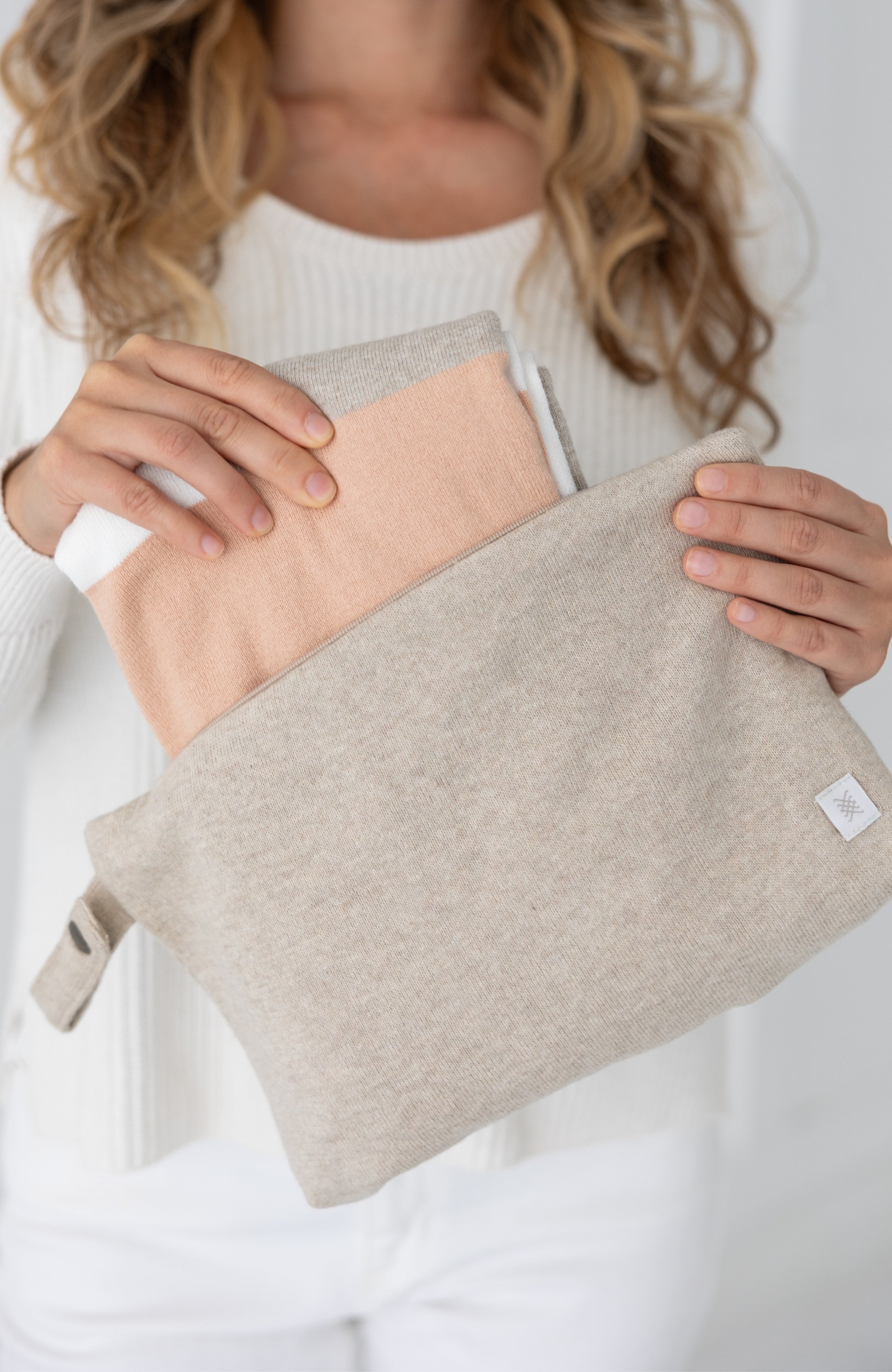 Woman shown pulling scarf out of the beige carry pouch