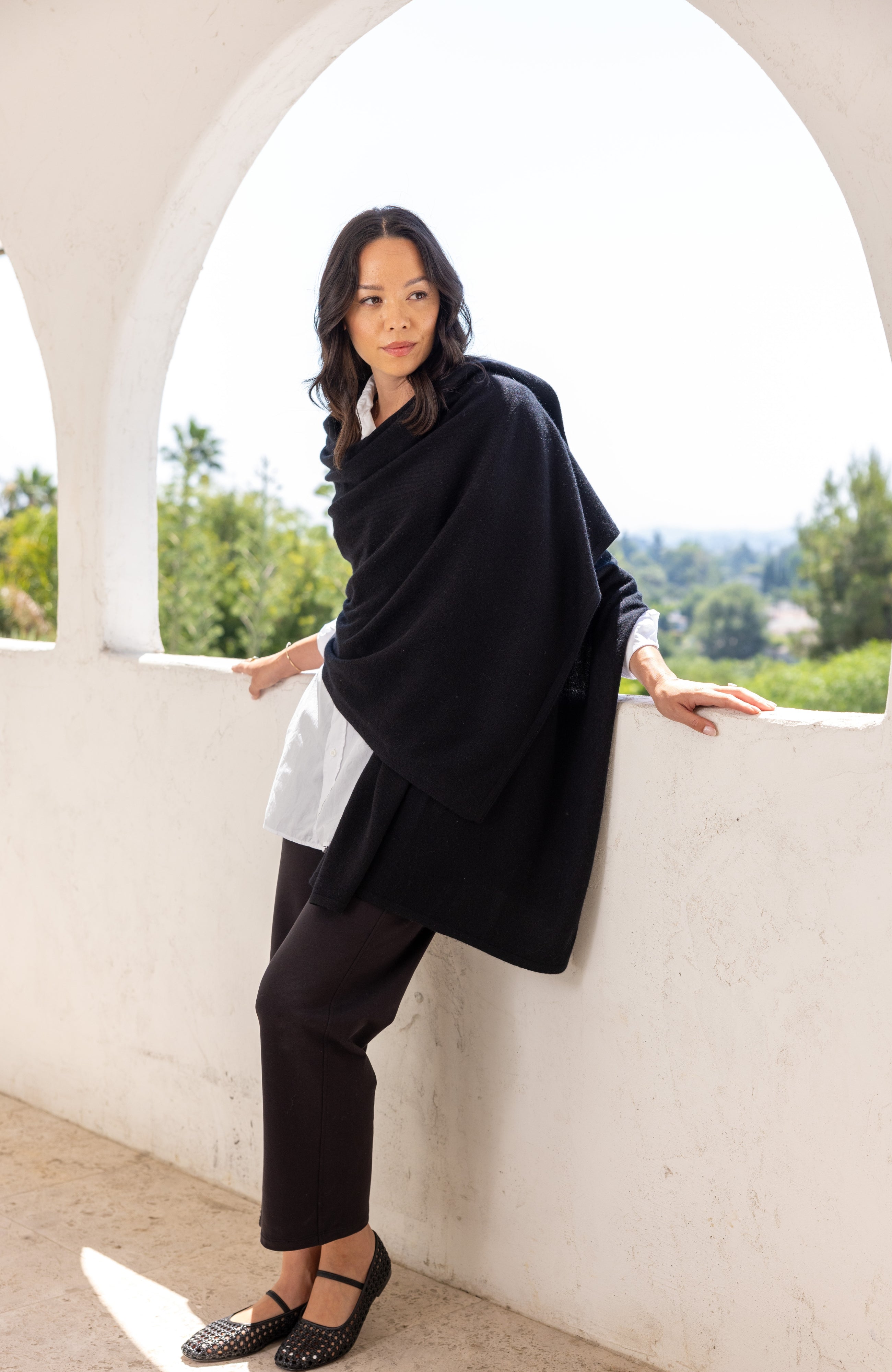 Woman shown wearing a black scarf draped around her shoulders