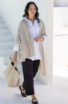 Woman shown wearing a beige scarf draped around her shoulders