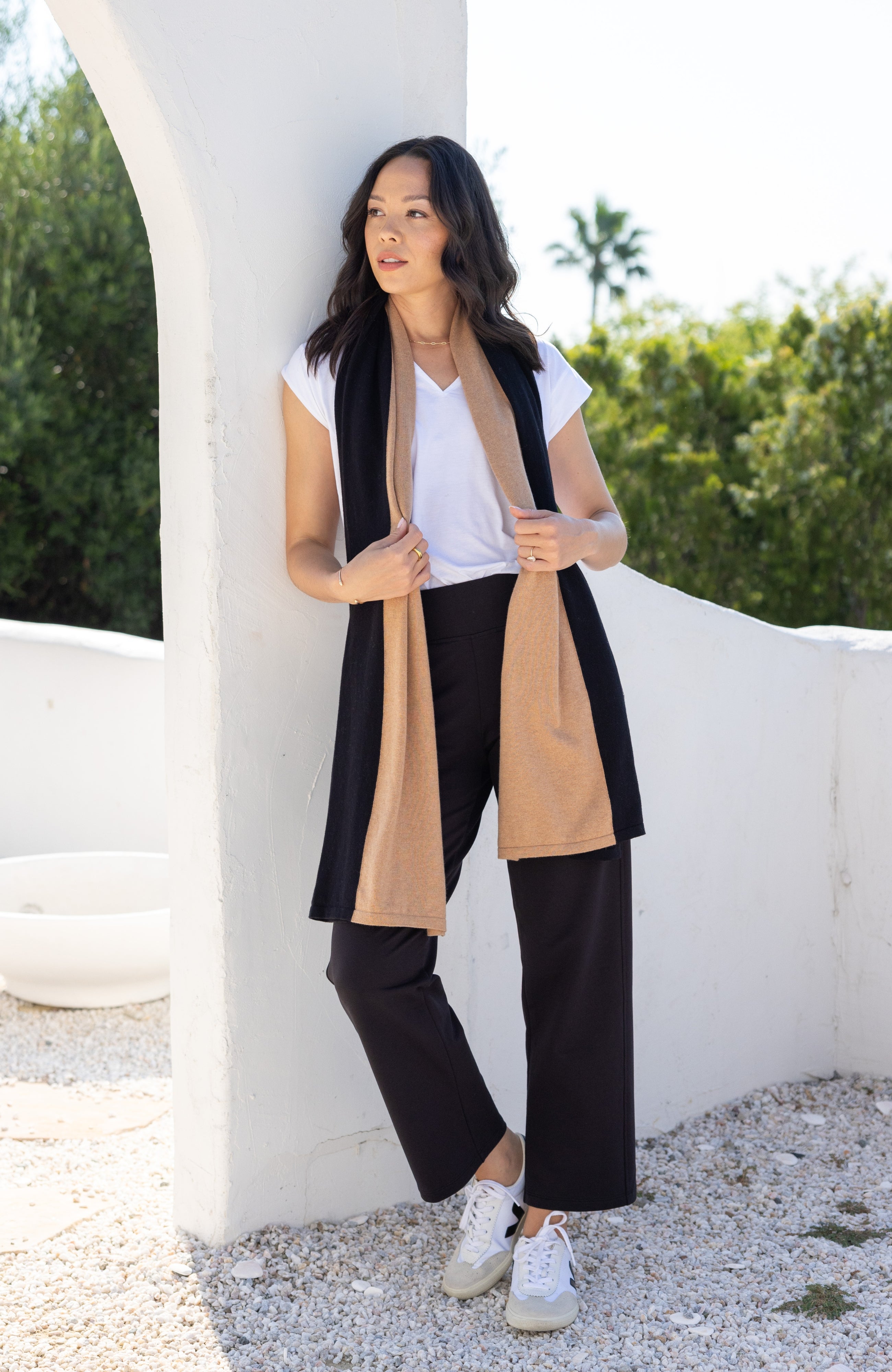 Woman shown wearing Black and Beige Scarf wrapped around her neck