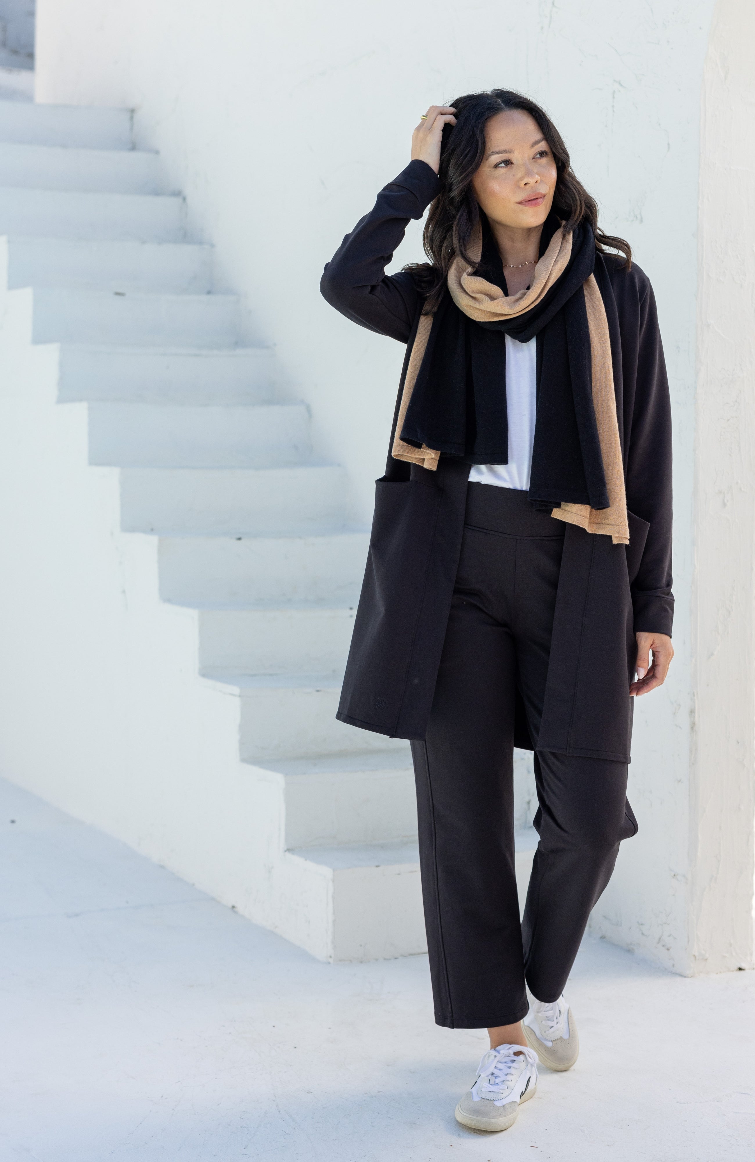 Woman shown wearing Black and Beige Scarf wrapped around her neck