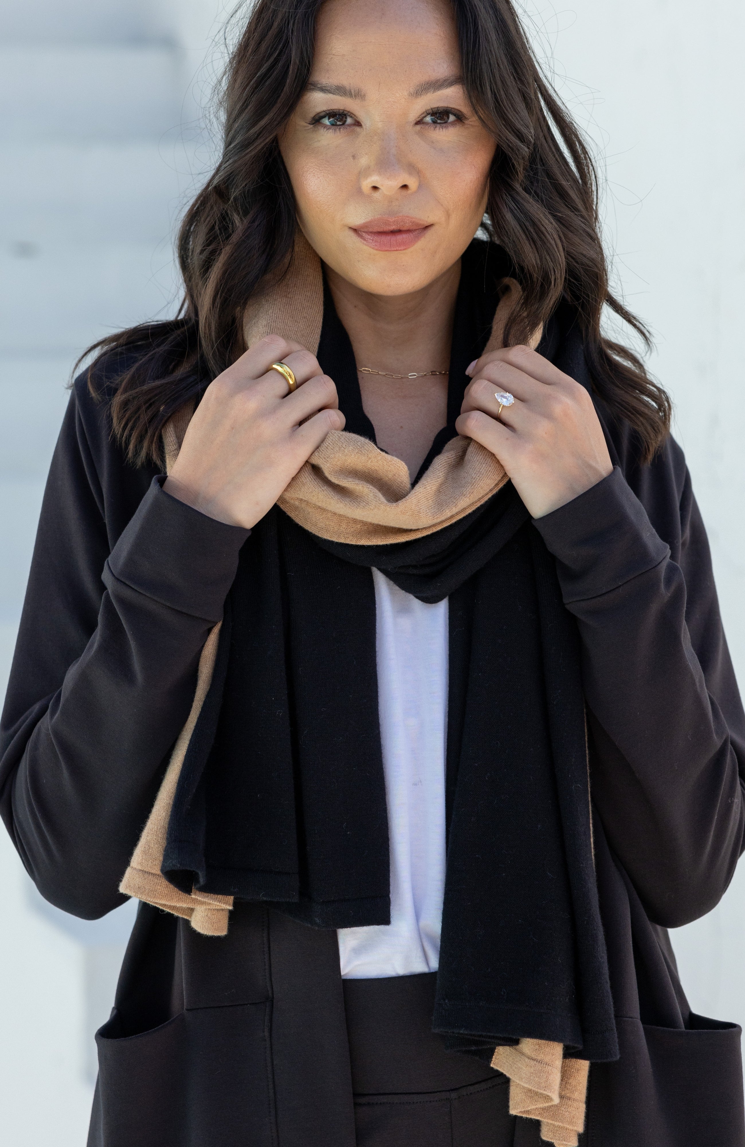 Woman shown wearing Black and Beige Scarf wrapped around her neck