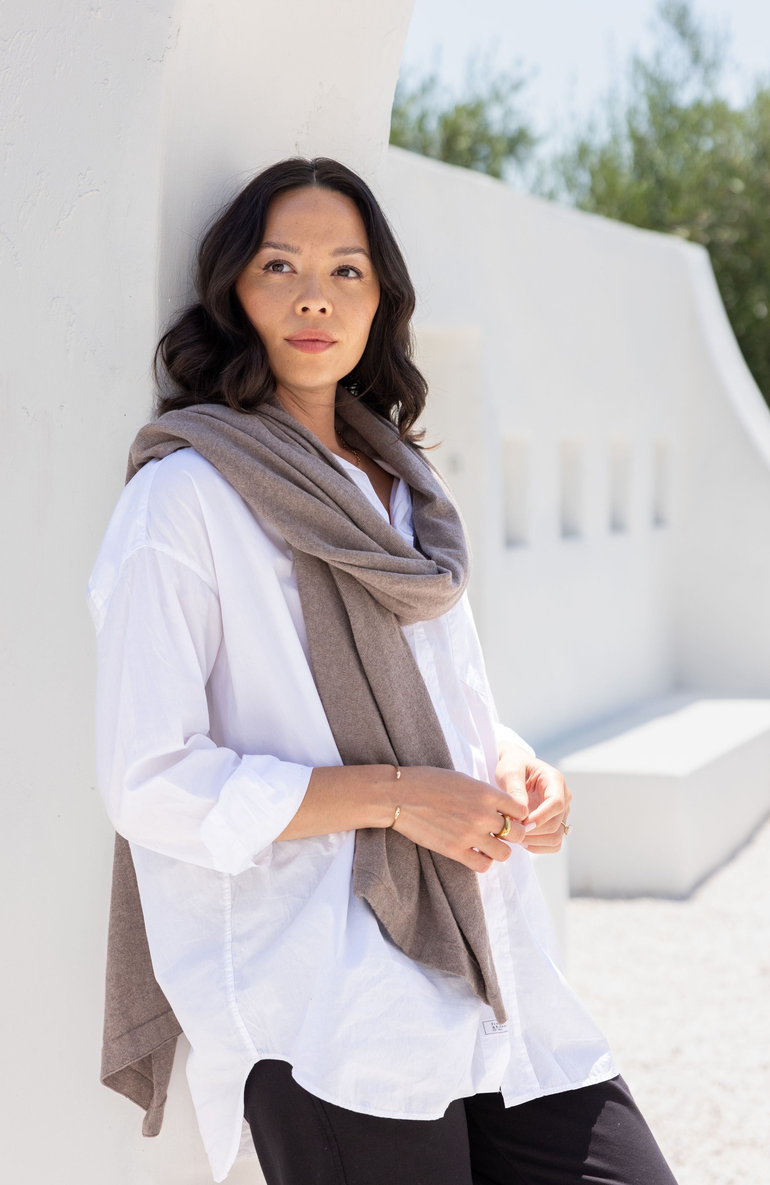 Women shown wearing a dark beige scarf wrapped around her neck