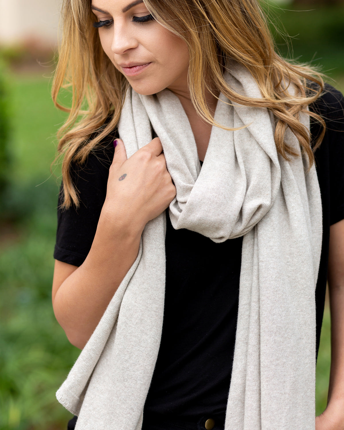 Woman wearing the Dreamsoft Travel Scarf in Birch Scarf which is a cream scarf, worn as the Modern Loop