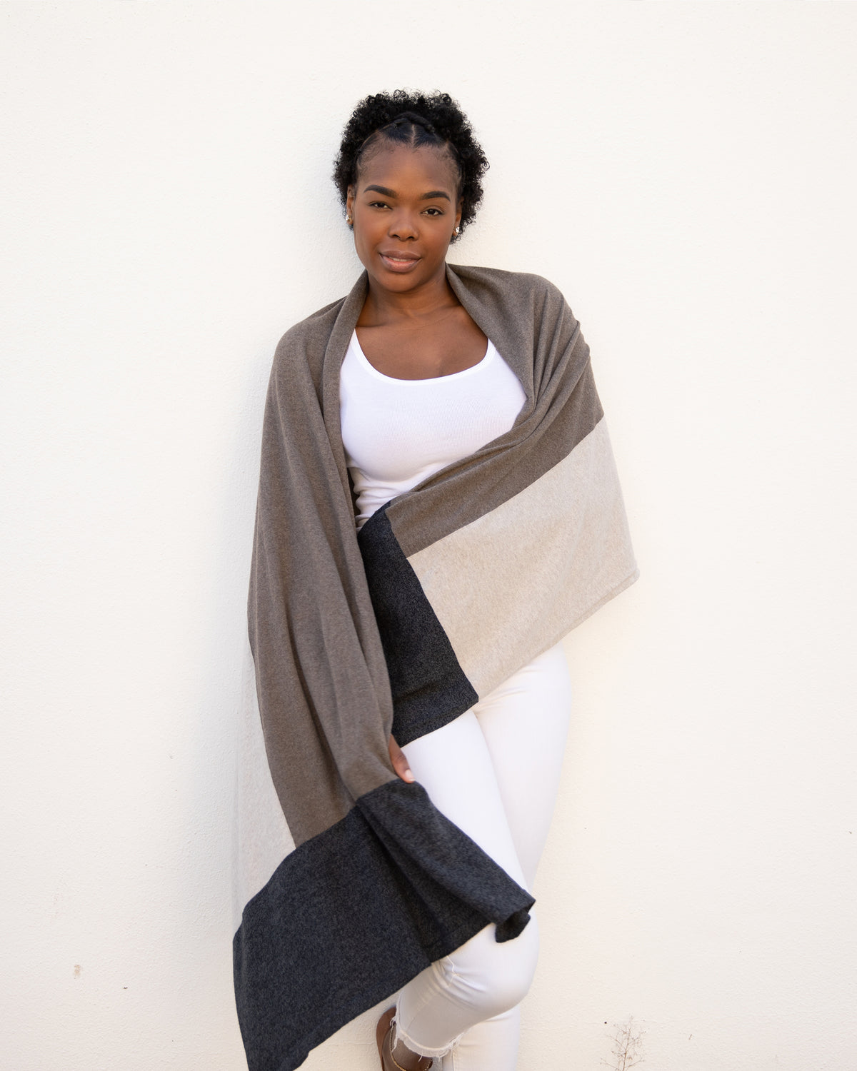 Woman wearing the Dreamsoft Travel Scarf in Brownstone Colorblock which is a brown, tan and gray scarf, worn as the Classic Drape around both of her arms