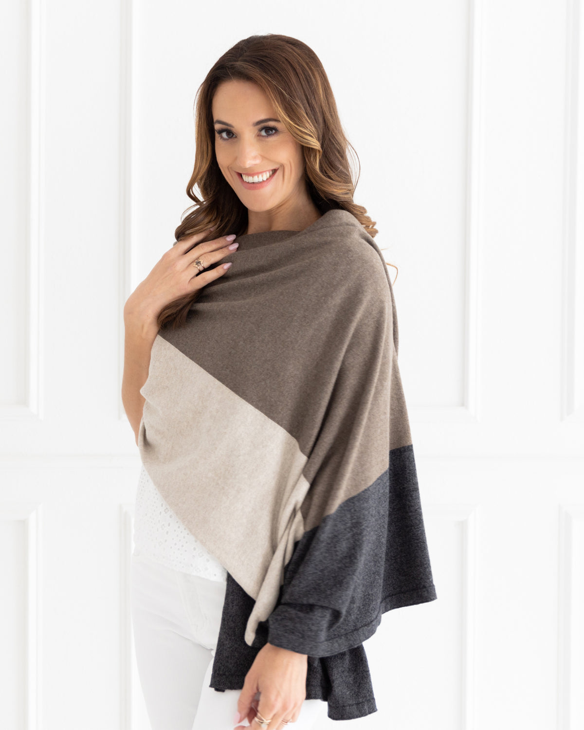 Woman wearing the Dreamsoft Travel Scarf in Brownstone Colorblock which is a brown, tan and gray scarf, worn as a wrap and smiling